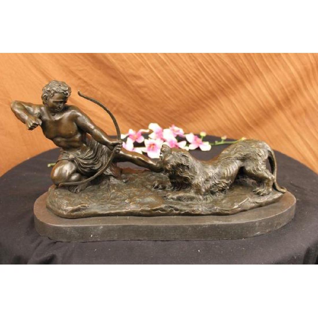 Man With Bow and Arrow Striking Lion Bronze Sculpture: This lovely sculpture of a man about to strike this lion with a bow and arrow. The lion has his mouth wide open ready to attack the man but the man wont give up to win this battle. The handmade bronze