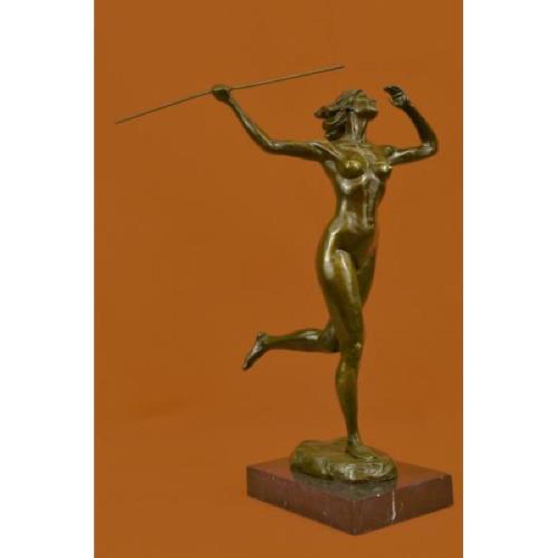 Nude Diana the Huntress Bronze Sculpture: A sexy and tough Amazon warrior stands proudly holding her spears. Her other arm is tense, highlighting her sculpted arms. Her large breasts are exposed and she is fully nude. She is a fighter in the 