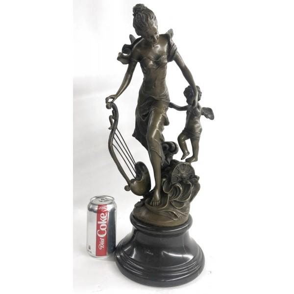 Fantasy Winged Fairy with Mythical Bronze Sculpture: A young cherub reaches to a fairy to gain her attention. The beautiful fairy reaches back to the cherub with a delicate to his playful curls. Sheâ€™s holding a musical Harps in this enchanting sc