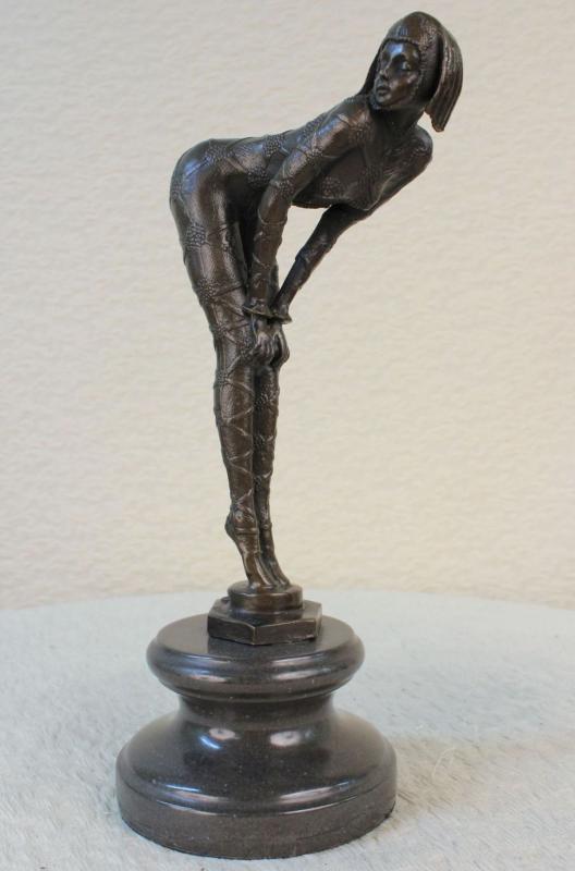 Woman in Seductive Pose Bronze Sculpture: The alluring woman is captured in a seductive pose as she bends her upper torso, hands resting on her knees, as her figure takes an L-shape. From her head to her dainty pointed toes, she wears a strap