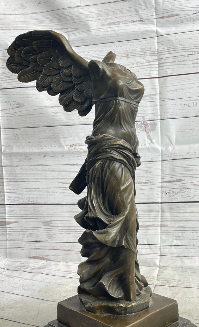Winged Nike Bronze Statue: This bronze sculpture was cast using the lost-wax method and stained with a brown patina finish and stands upon a marble base. Dimensions: Height 19 X Width 10 inches. Weight: 21 LBS.