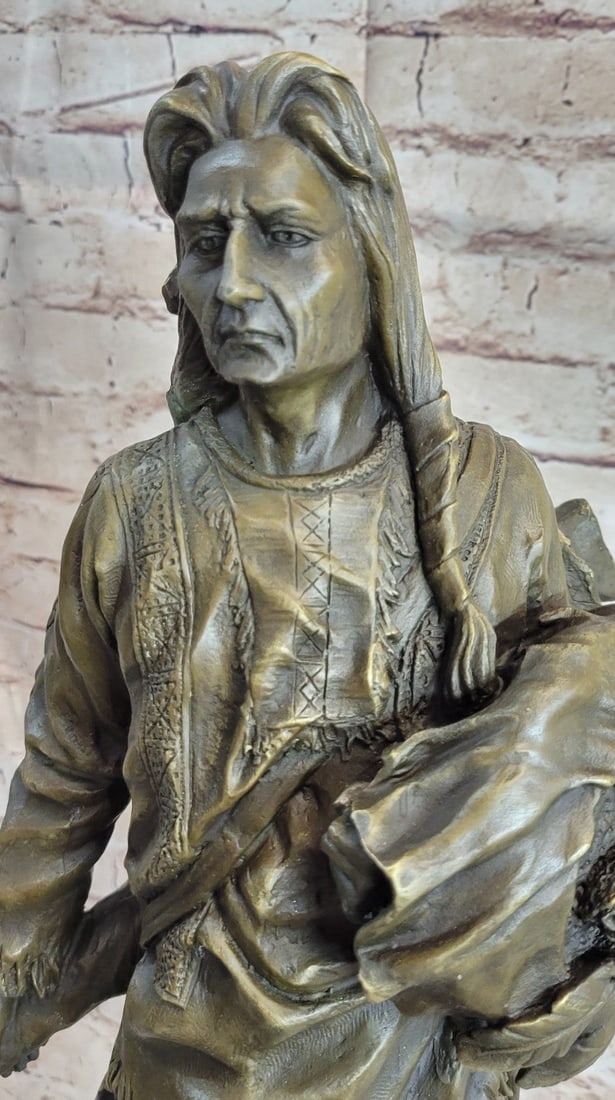 Chief With Shield Gun Full Headdress Bronze Statue: This impressionistic Sculpture of the Indian chief instills a sense of pride, respect, and honor. He has a traditional necklace. His hair is straightened and falls onto his back. His face is old and w