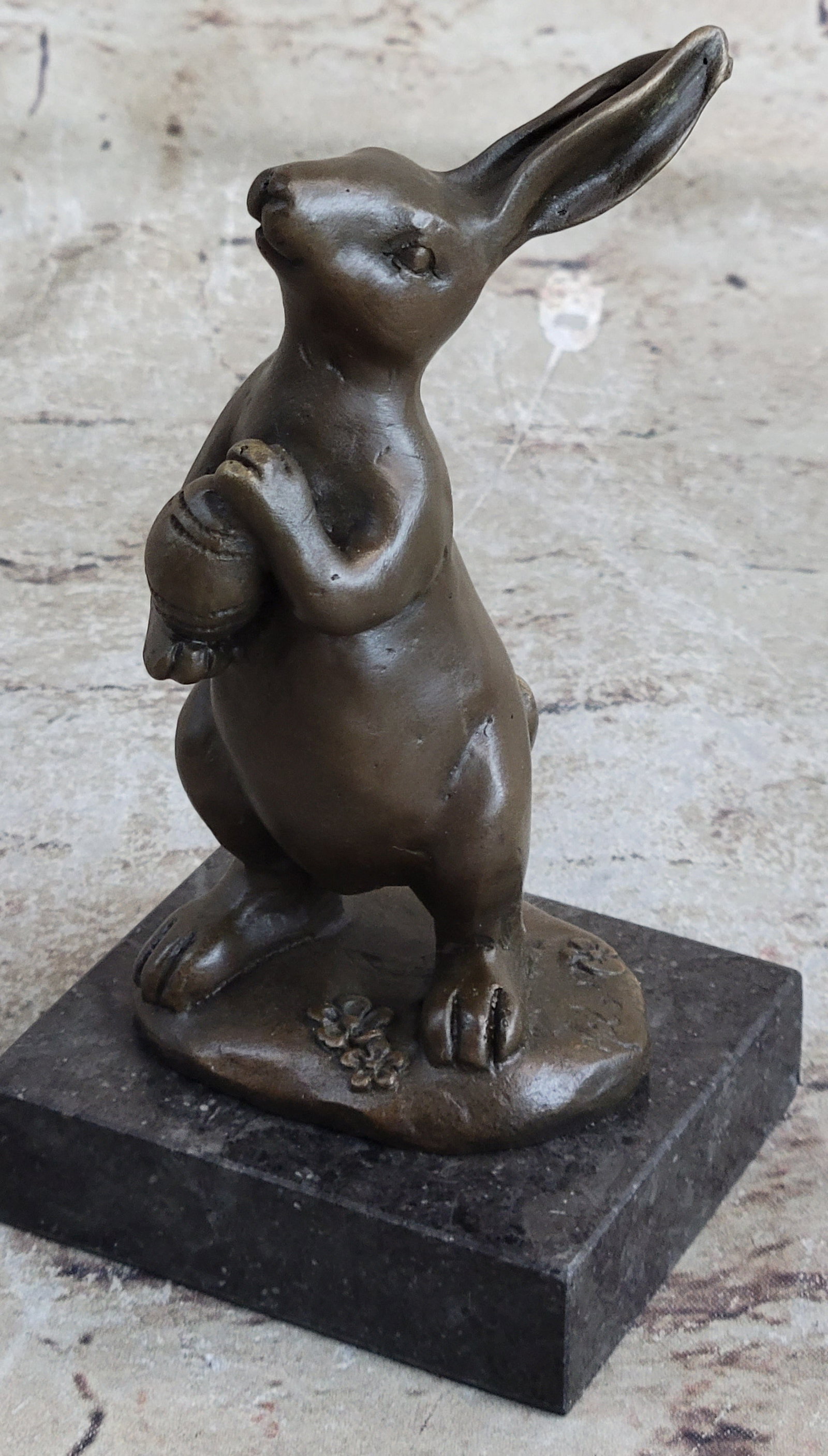 Mini Easter Bunny Bronze Sculpture: This cute and cuddly Lil lady looks up with the sweetest look and holds a tiny basket full of flowers in her tiny arms. This little bunny is the perfect touch of decor for a sweet and cute look. Her e