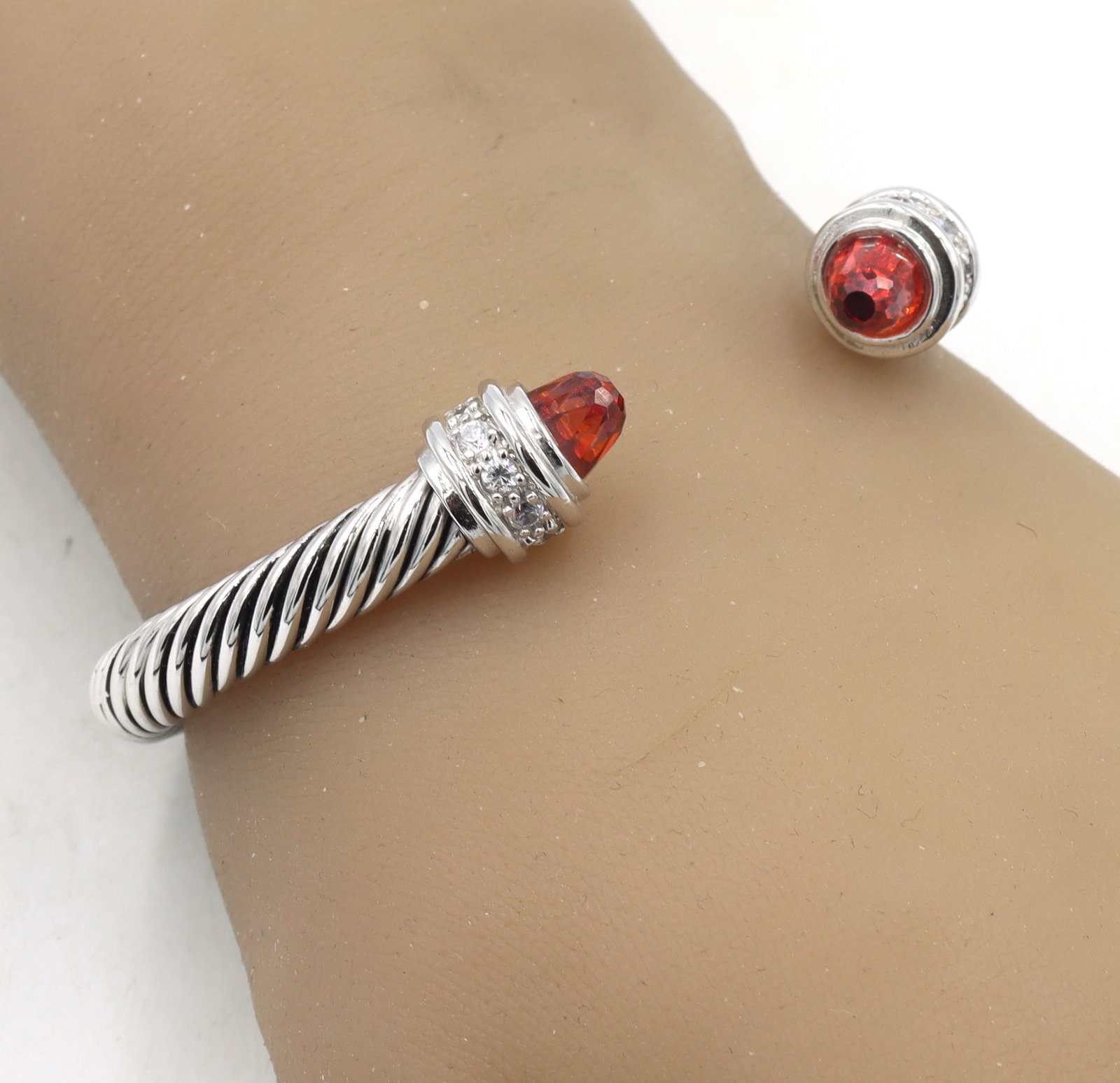 925 Sterling silver Cabel classic cuff bangle with with and red CZ: 925 Sterling silver Cabel classic cuff bangle with with and red cubic zirconia. The total weight of the bangle is 33.10 grams.