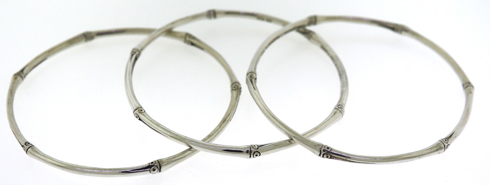 Trendy Silver John Hardy Set of 3 Bamboo Bangles: This Trendy 925 Sterling Silver Set of Bangle Bracelets designed by John Hardy features their Bamboo Motif throughout all of the bangles. This set of bangles weighs approx. 35.20 Grams.