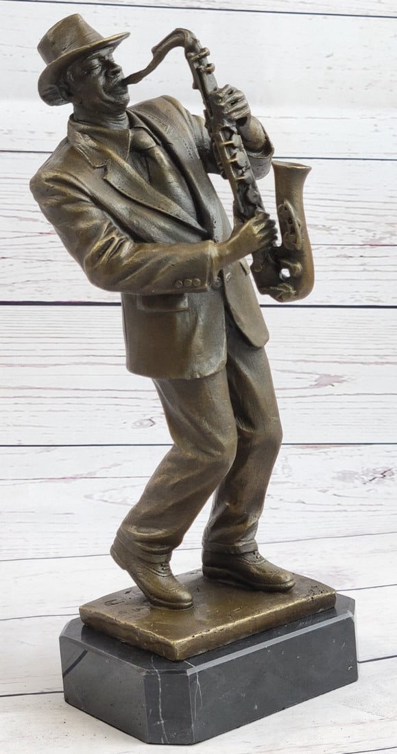Saxophone Player Bronze Sculpture: The unique statue will bring an added touch into any room in your home or office. Cast bronze sculpture features the forms of a saxophone player and saxophone. The statue is cast using the sand-castin
