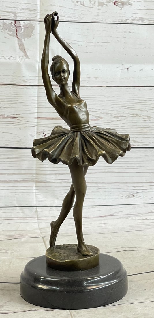 Ballerina Bronze Sculpture Figurine: The ballerina stands tall and elegant as she looks to the heights of the balcony lovingly admiring the audience. She wears a tiara and a modern tutu, the classic costume of the ballet dance, which has