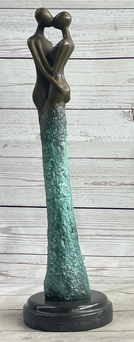 First Kiss Bronze Statue: The suggestive male and female figures, in an act of true affection, make a connection. With interlocked arms and lips, they initiate the integration of two souls becoming one. The green patina-coated