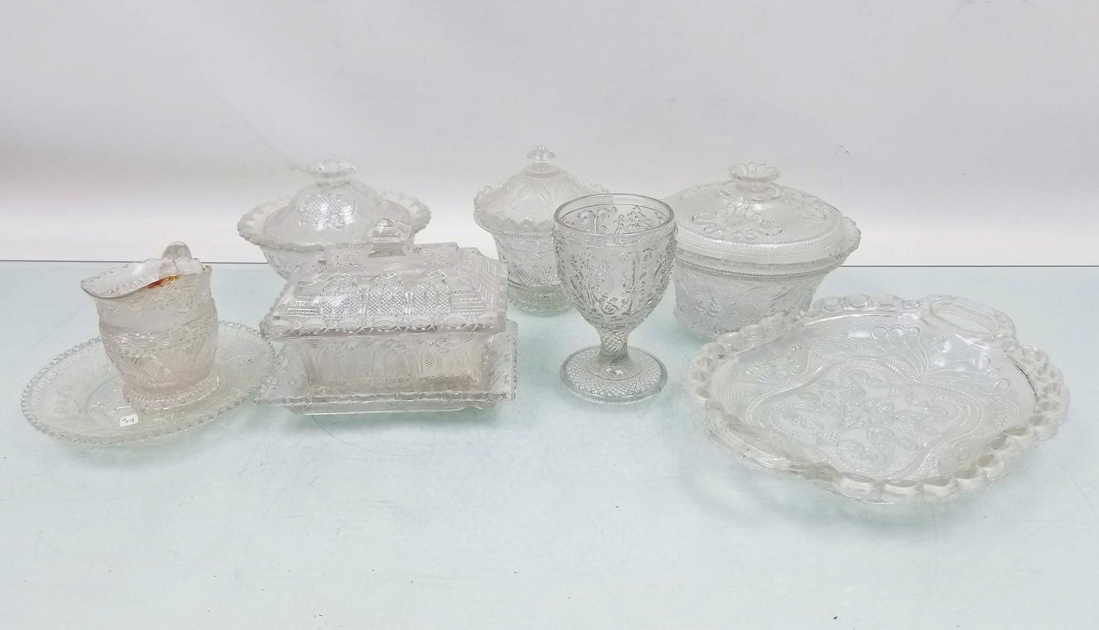 Eight Pieces of Nineteenth Century Lacy Glassware: (8) Pieces of Nineteenth Century Lacy Glassware: Covered Sugar Bowl c. 1830-1845, cover is possibly not original to bowl but similar era and style, several small chips on rim of bowl - Goblet c. 1830s