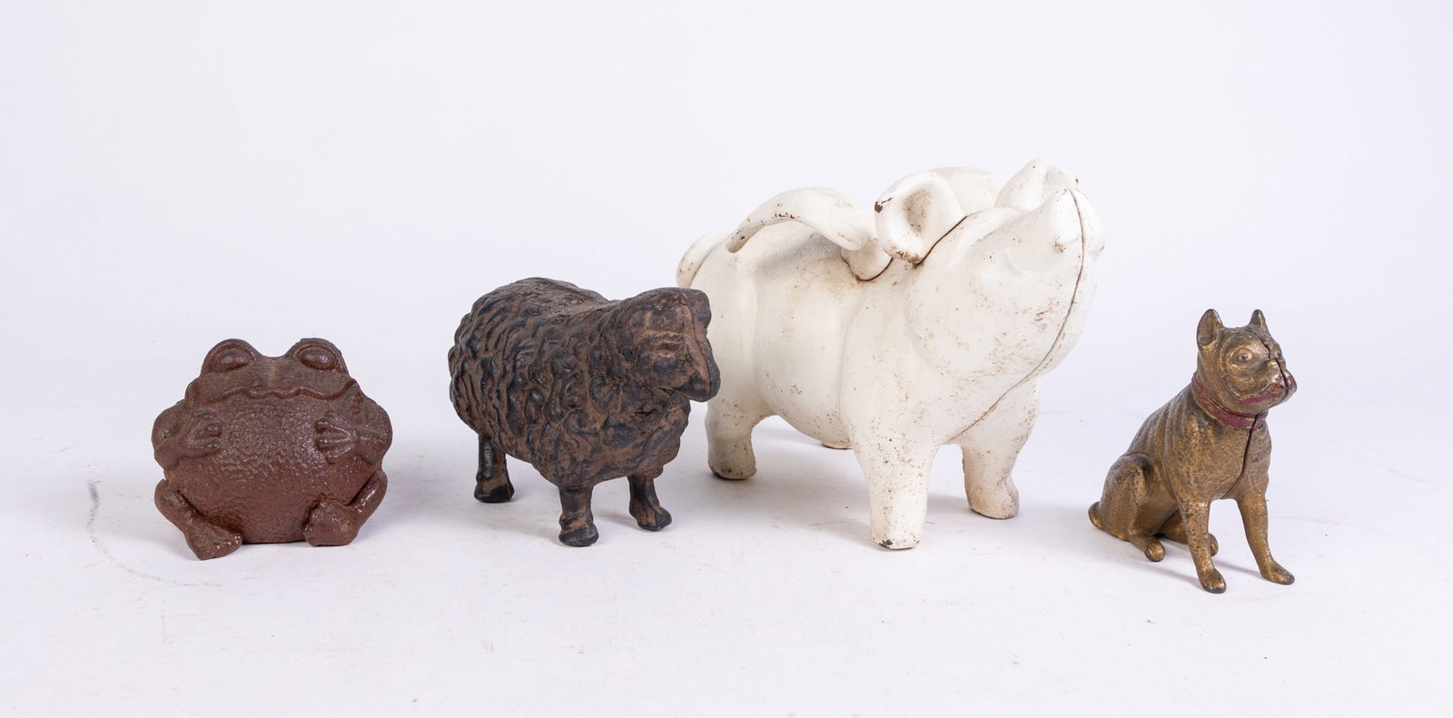 Four Cast Iron Figures: Four Cast Iron Figures: pig with wings bank - cast iron sheep - cast iron vintage bulldog bank - cast iron frog Size 6" x 6" x 10" Literature Brooks Auction is not responsible for outbids. Questions