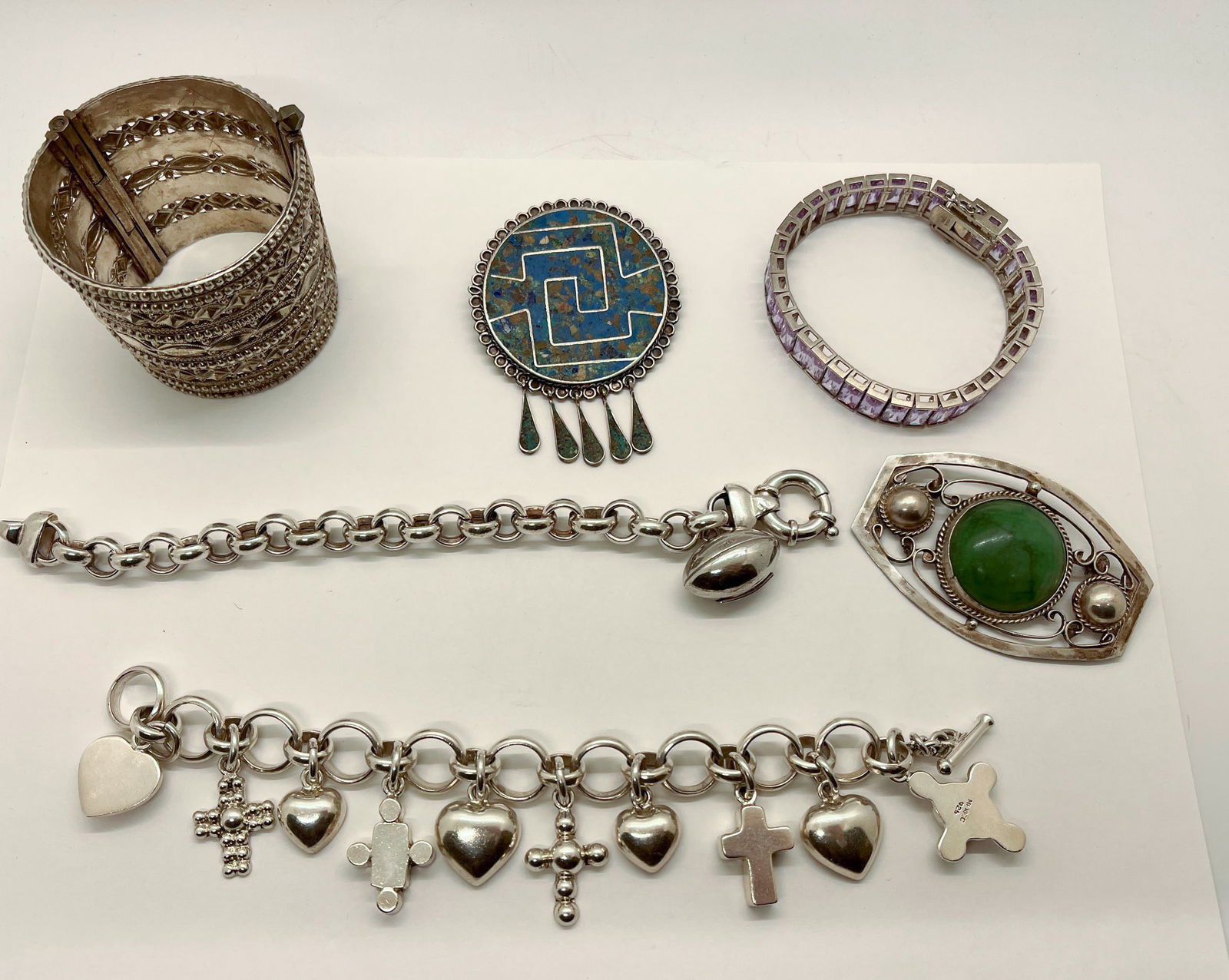 Sterling Silver Jewelry Lot: Sterling Silver Jewelry Lot: (2) Charm bracelets - (2) Pins - (1) Rhinestone studded bracelet - (1) Cuffed Bracelet Literature Brooks Auction is not responsible for outbids. Questions? Call the offic