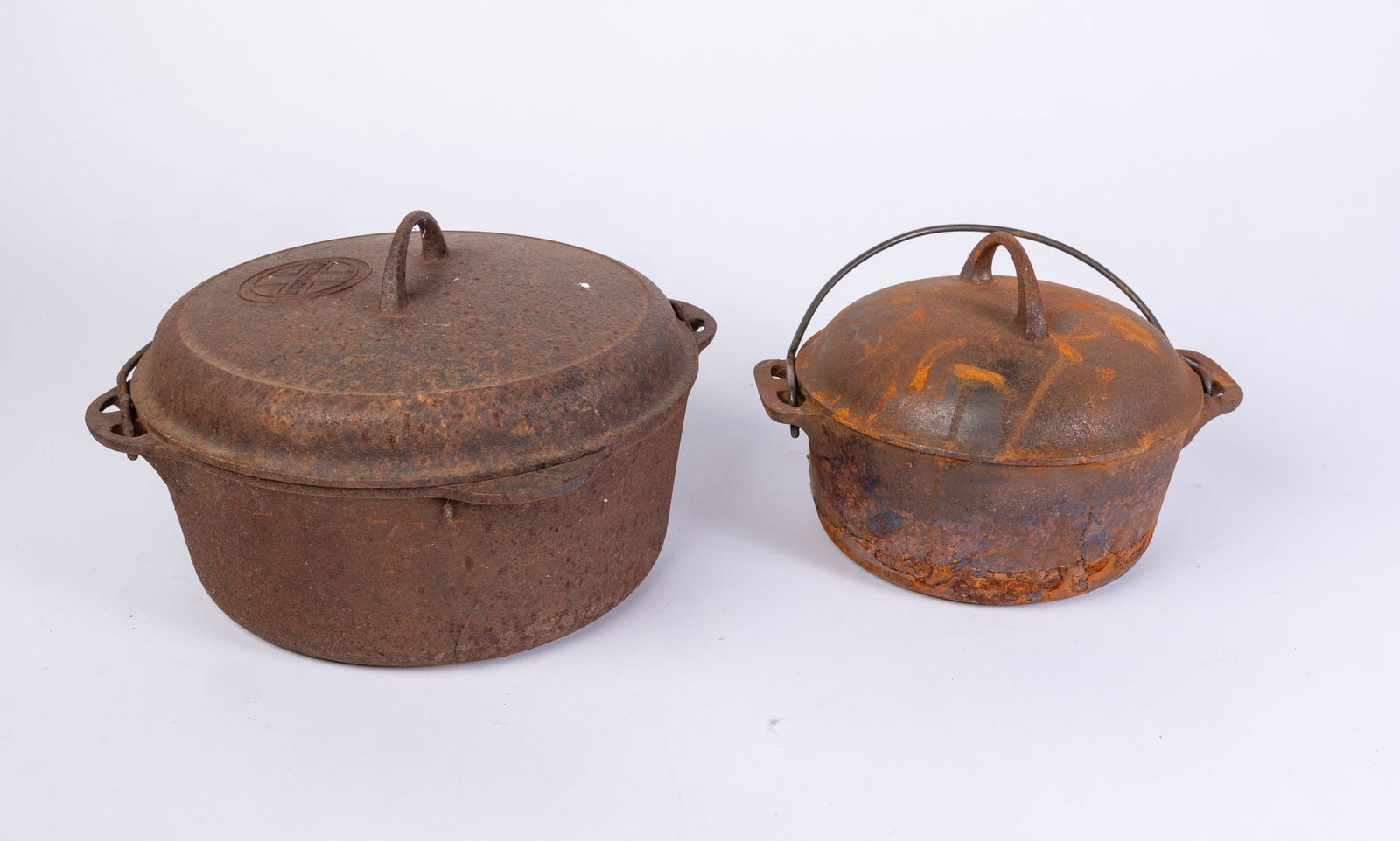 Two Griswold Cast Iron Pots: Two Griswold Cast Iron Pots, heavy rust, larger pot has a crack in the bottom Size 7" x 13" x 13" Literature Brooks Auction is not responsible for outbids. Questions? Call the office at (856) 694-29