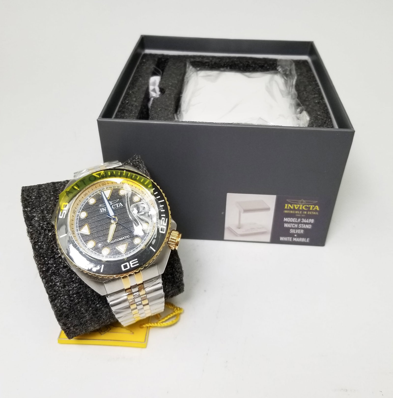 Invicta Pro Diver Men's Automatic Watch with Stand: Invicta Pro Diver Men's Automatic Watch with Stand: Silver colored watch stand with marble detailing, Model #34498 Literature Brooks Auction is not responsible for outbids. Questions? Call the office