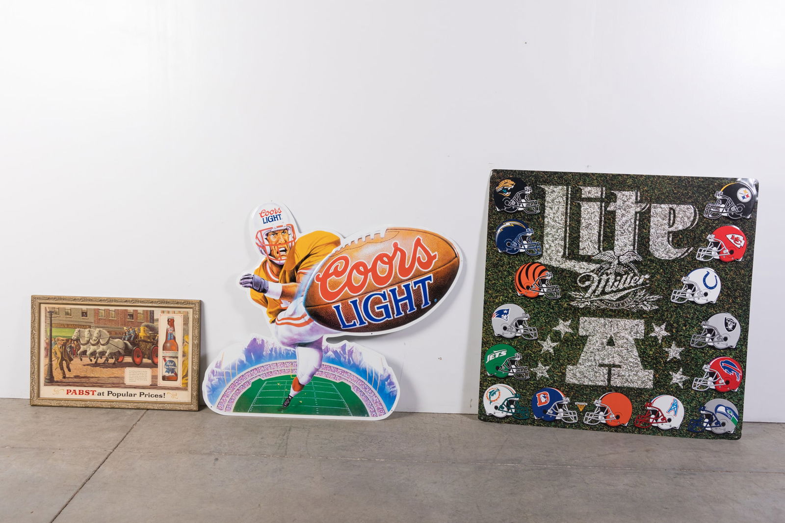 Three Vintage Beer Advertising Signs: Three Vintage Beer Advertising Signs: metal Coors Light football player advertising sign - Miller Lite metal football helmets sign - Pabst at popular prices 1970's framed advertisement Size 30" x 30"