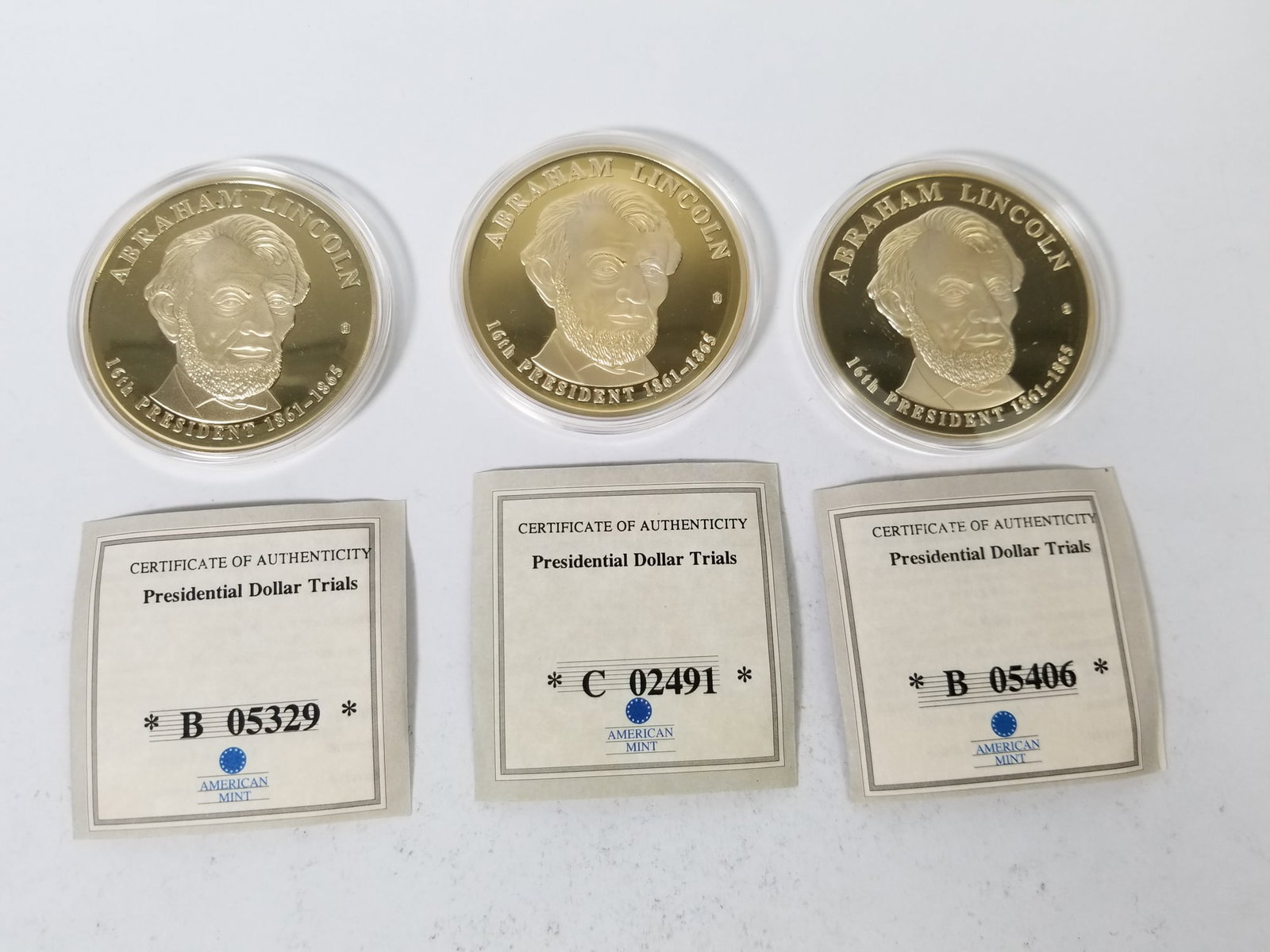 Three Abraham Lincoln Presidential Dollar Trial Coins: (3) Abraham Lincoln Presidential Dollar Trial Coins, with certificate of authenticity, copper layered in 24K Gold Literature Brooks Auction is not responsible for outbids. Questions? Call the office