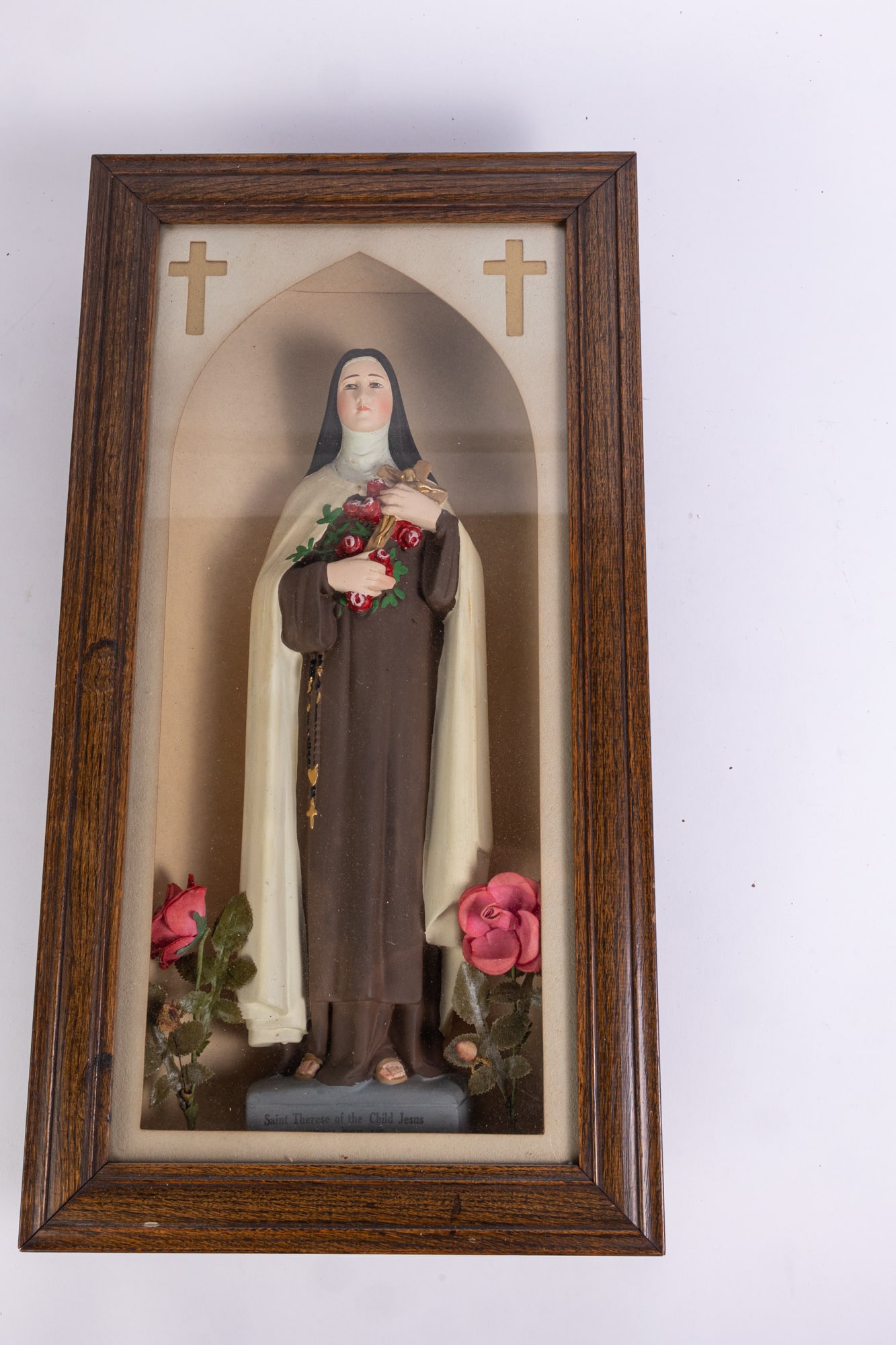 Saint Therese Christian Nicho Shrine: Saint Therese Christian Nicho Shrine: An oak framed nicho shrine having a St. Therese statue inside. The statue is holding a bouquet of pink roses with a gold tone crucifix and black beaded rosary; th