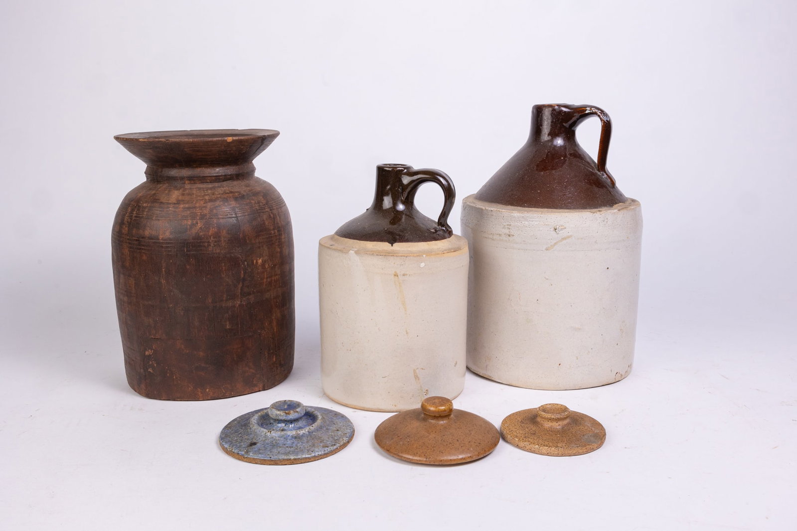 Stoneware Jugs - Wood Carved Pot: Stoneware Jugs - Wood Carved Pot - (3) small stoneware lids Size 10"H (wood pot) Literature Brooks Auction is not responsible for outbids. Questions? Call the office at (856) 694-2960 or email us di