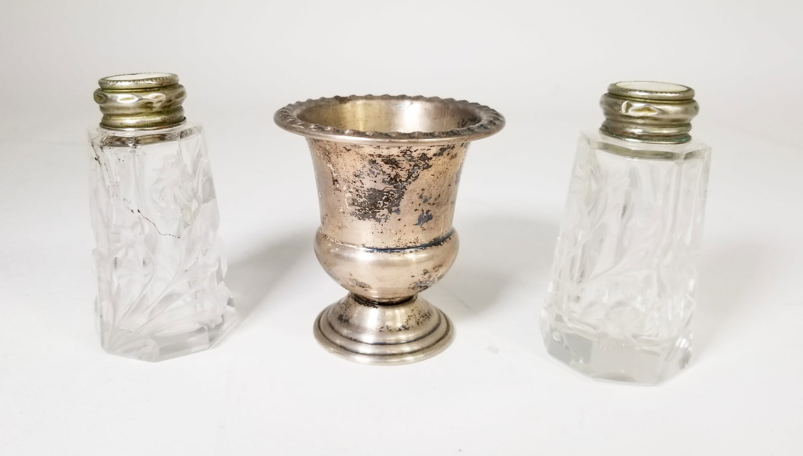 Sterling Silver Goblet and Crystal Cut MOP Topped Shakers: Sterling Silver Goblet and Crystal Cut MOP Topped Shakers, goblet marked Rogers Sterling, total weight of goblet 39.8 grams Literature Brooks Auction is not responsible for outbids. Questions? Call th