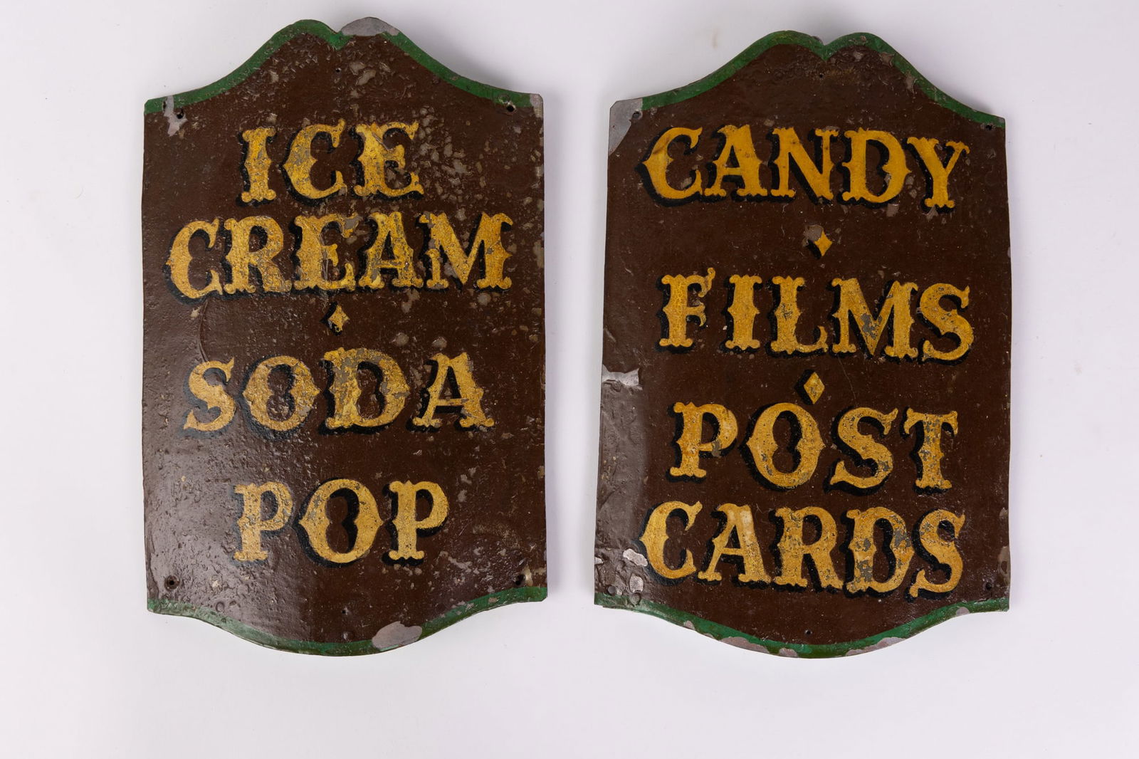 Pair of Antique Hand Painted Soda Fountain Trade Signs: The signs read "Ice Cream - Soda Pop - Candy - Films - Postcards" and are constructed of Tin on Wood. Size 10" x 7" Literature Brooks Auction is not responsible for outbids. Questions? Call the offi
