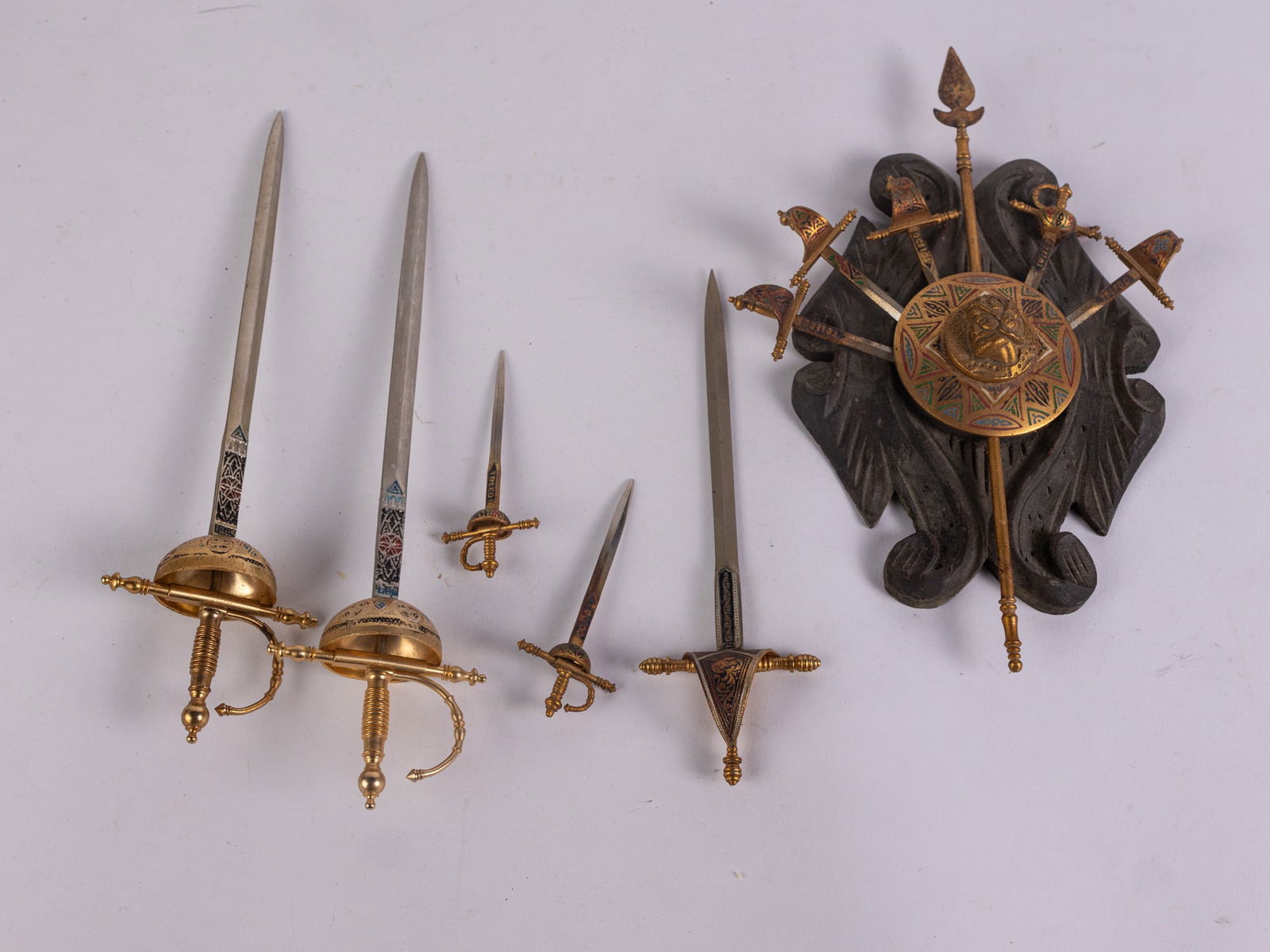 Vintage Toledo Spanish Damascene Coat of Arms & Miniature Swords: Vintage Toledo Spanish Damascene Coat of Arms & Miniature SwordsSize7" x 12" x 12"LiteratureBrooks Auction – Online Auction Terms & Conditions Contact: (856) 694-2960 | info@brooks.auction READ