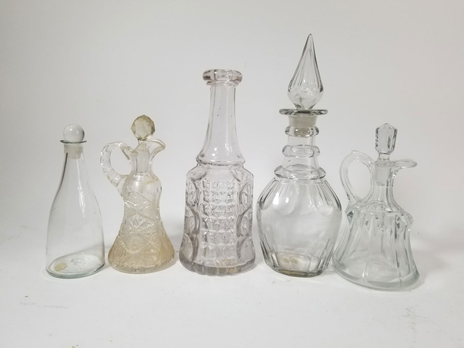 Antique Decanter Grouping ft. EAPG Waffle & Thumbprint: Antique Decanter Grouping ft. EAPG Waffle & ThumbprintSize7" x 12" x 12"LiteratureBrooks Auction – Online Auction Terms & Conditions Contact: (856) 694-2960 | info@brooks.auction READ BEFORE