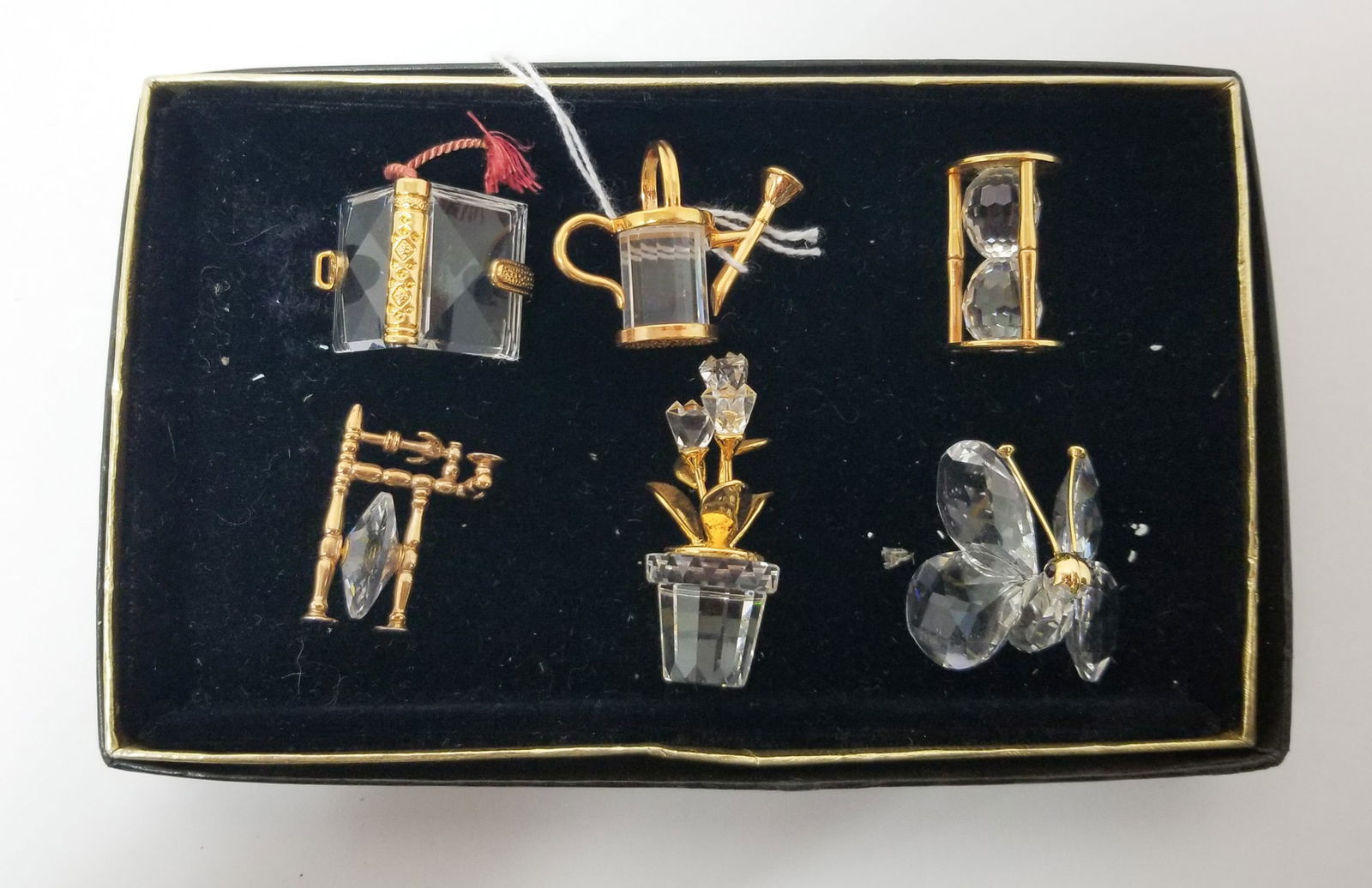 6 Swarovski Crystal " Memories " Mini Figurines: 7 Swarovski Crystal " Memories " Mini figurines Including Watering Can, Flower Pot, Spinning Wheel, Hourglass, Butterfly, And Book.LiteratureBrooks Auction – Online Auction Terms & Conditions