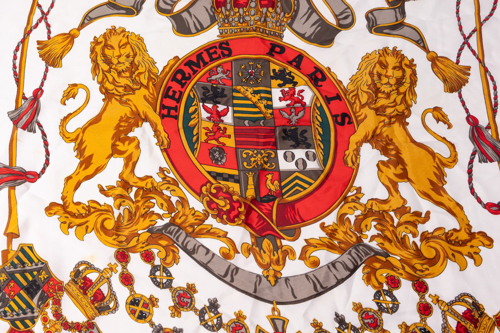 Hermes | Silk Scarf w/ Lion Crest: Made in Paris and featuring Hermes' timeless "Crête De Lions". Condition is consistent with a vintage piece of its age, with some stains & minor spots which are pictured.Size34" x