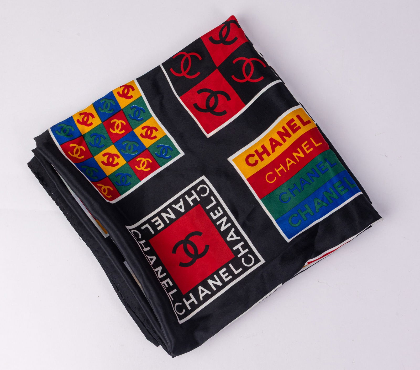 Chanel | Colorblock Logo Silk Scarf: This vibrant multicolored scarf features the Iconic CC logo and a geometric colorblock motif. Condition is consistent with a vintage piece of its age.Size34" x 34"LiteratureBrooks Auction –