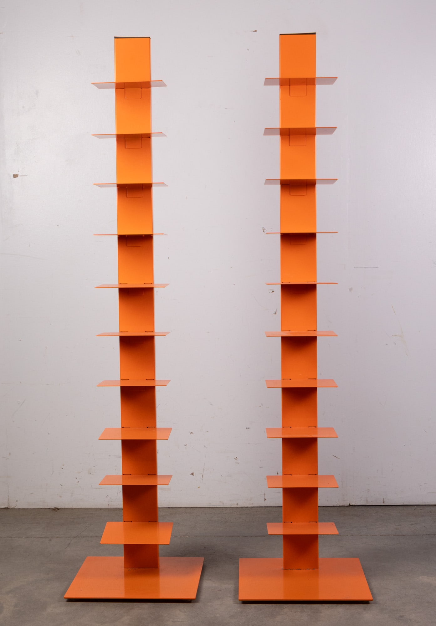 After Bruno Rainaldi | Italian Modern "Sapiens" Book Shelf: In the style of Ptolomeo Bookcase or the Sapiens, a "floating" book stand with cantilevered metal shelves tucking into a 6' stand. Orange enamel.Size59.5" x 14" x 14"LiteratureBrooks Auction –
