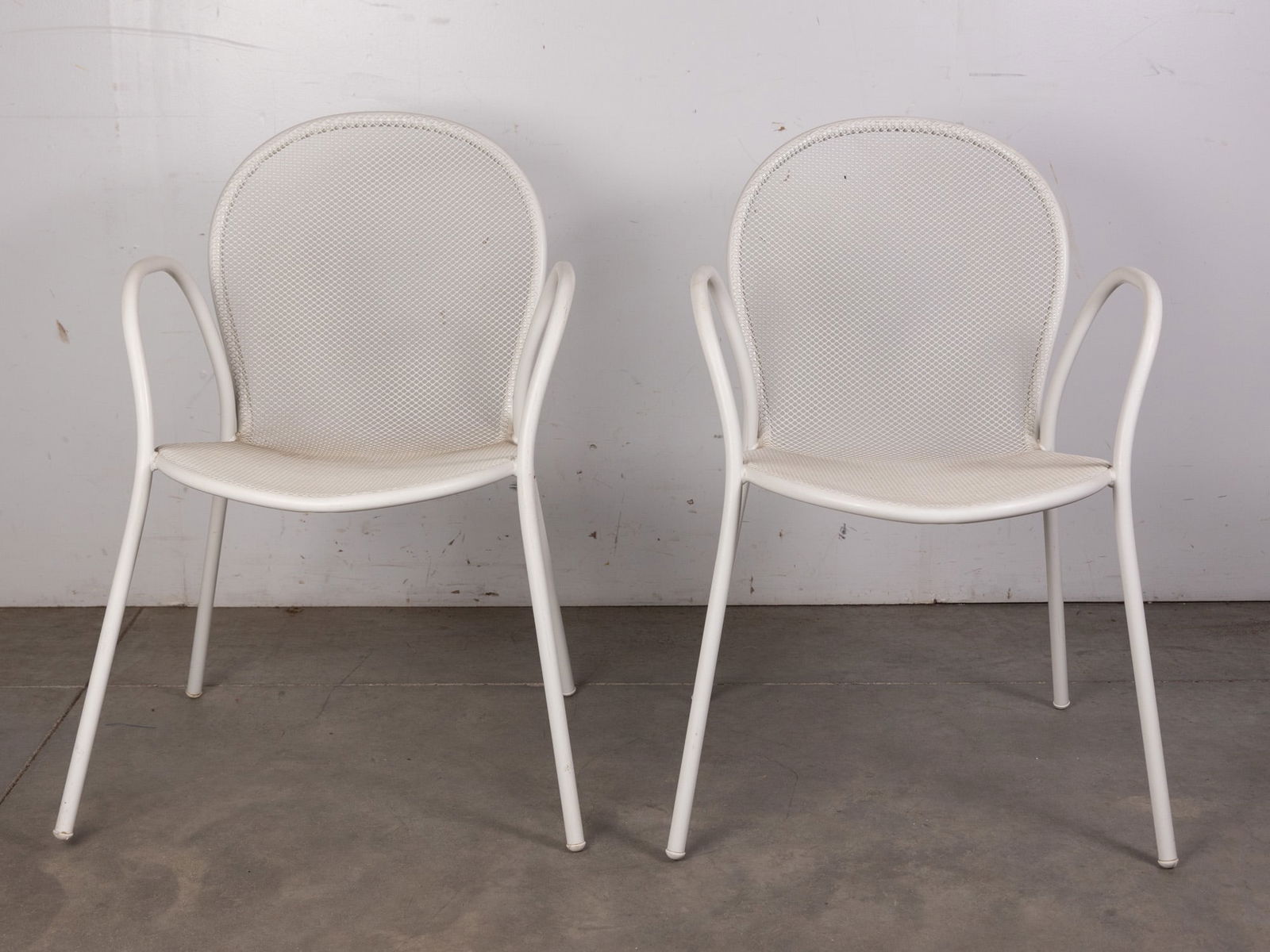 Emu Rio | (2) Italian Modern Mesh Arm Chairs: Featuring durable powder-coated metal frames and breathable mesh seats and backs, they offer both comfort and weather-resistant functionality. Their minimalist silhouette and refined lines make them s