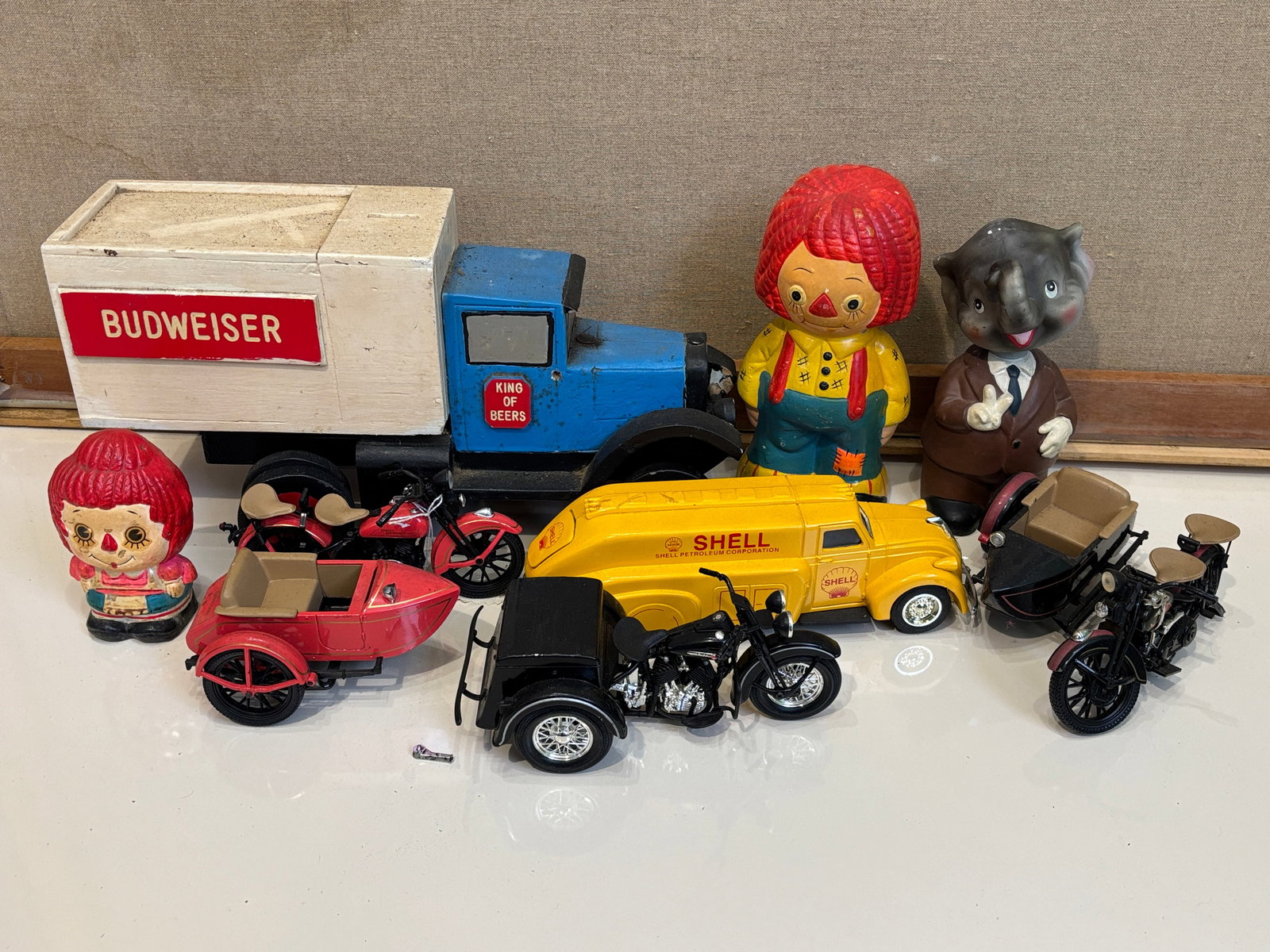 Assortment of Novelty Coin Banks: Assortment of Novelty Coin Banks featuring vintage Budweiser folk art truck Literature Brooks Auction – Online Auction Terms & Conditions Contact: (856) 694-2960 | info@brooks.auction READ BEFOR
