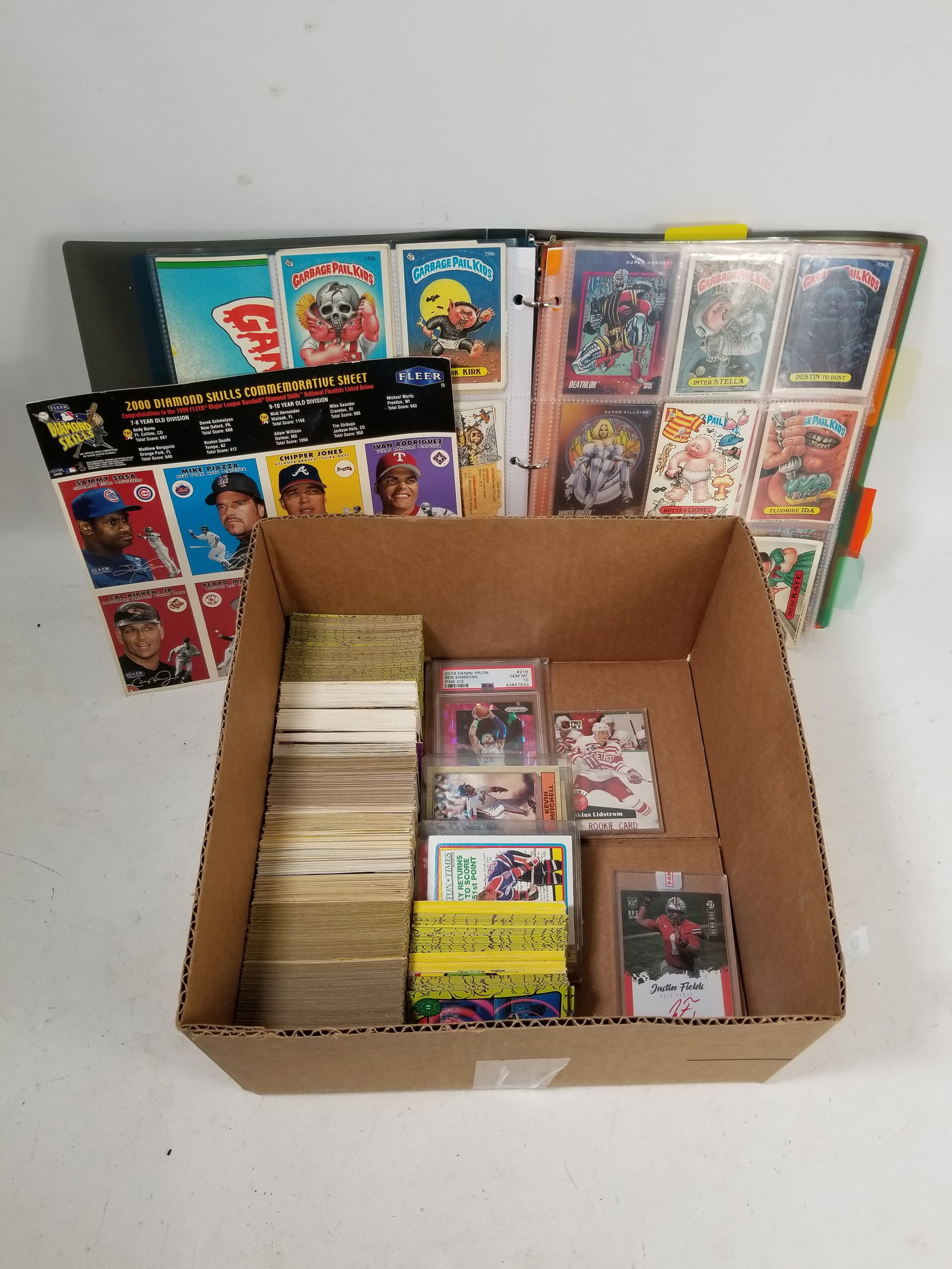 Assortment of 1970s-2000s Trading Cards: Assortment of 1970s-2000s Trading Cards featuring uncirculated Justin Fields rookie autograph, 1980s garbage pail kids, Ben Simmons PSA 10, and rookie cards of Sergei Fedorov and Niklas Lidstrom. Lite