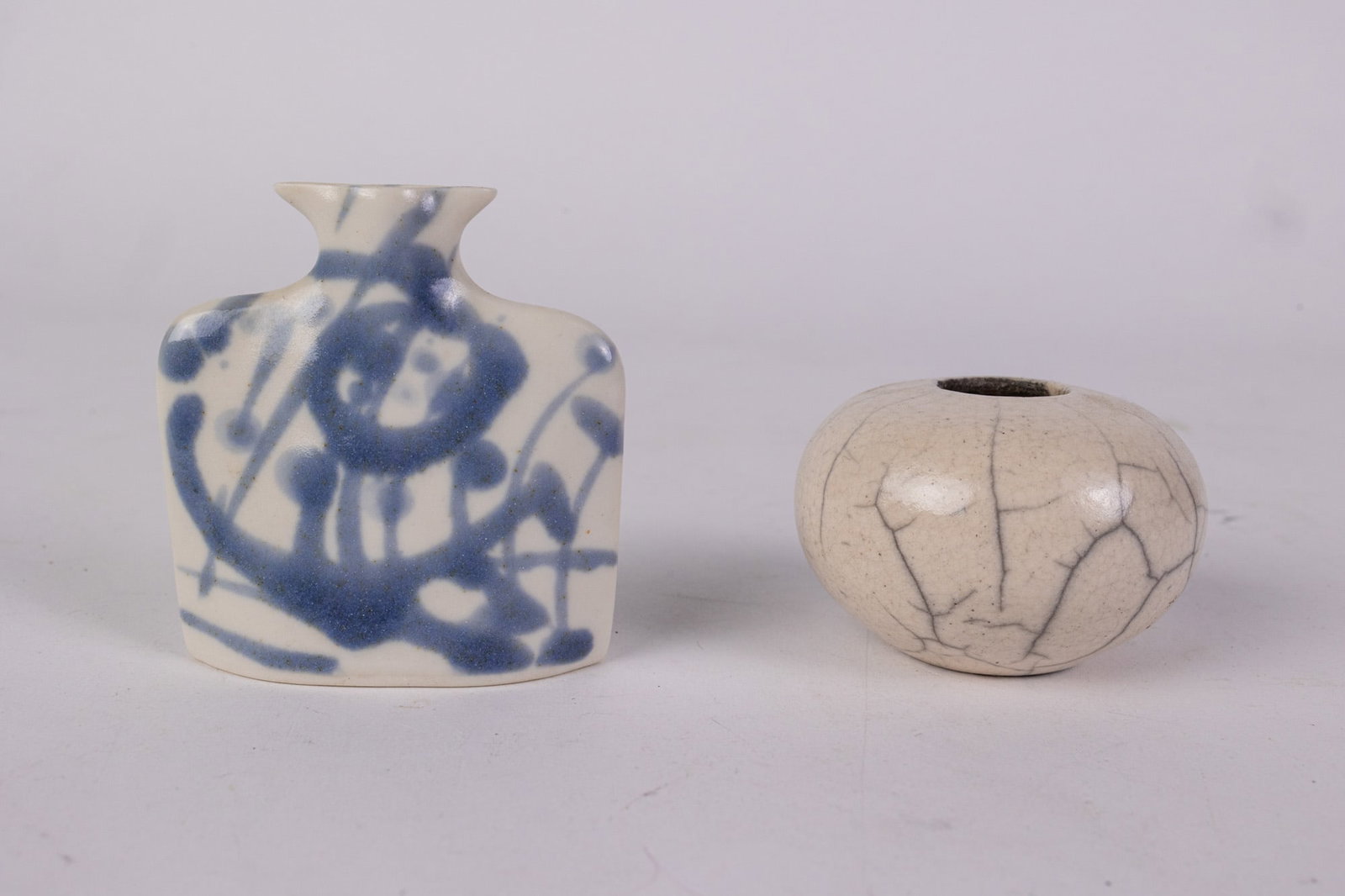 Two Pieces of Studio Pottery: Two Pieces of Studio Pottery: Lot includes small blue and white vase marked "ESP" as well as a small oval vase, signed on the bottom, but signature is unable to be deciphered. Size 3" H Literature Bro