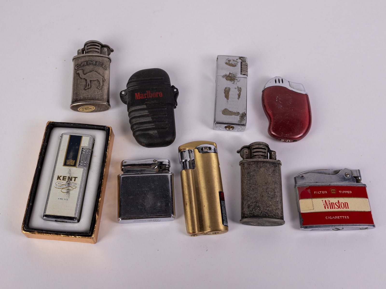 Lot of Assorted Vintage Lighters Featuring Cigarette Advertising: Lot of Assorted Vintage Lighters Featuring Cigarette Advertising Size 7" x 12" x 12" Literature Brooks Auction – Online Auction Terms & Conditions Contact: (856) 694-2960 | info@brooks.auction