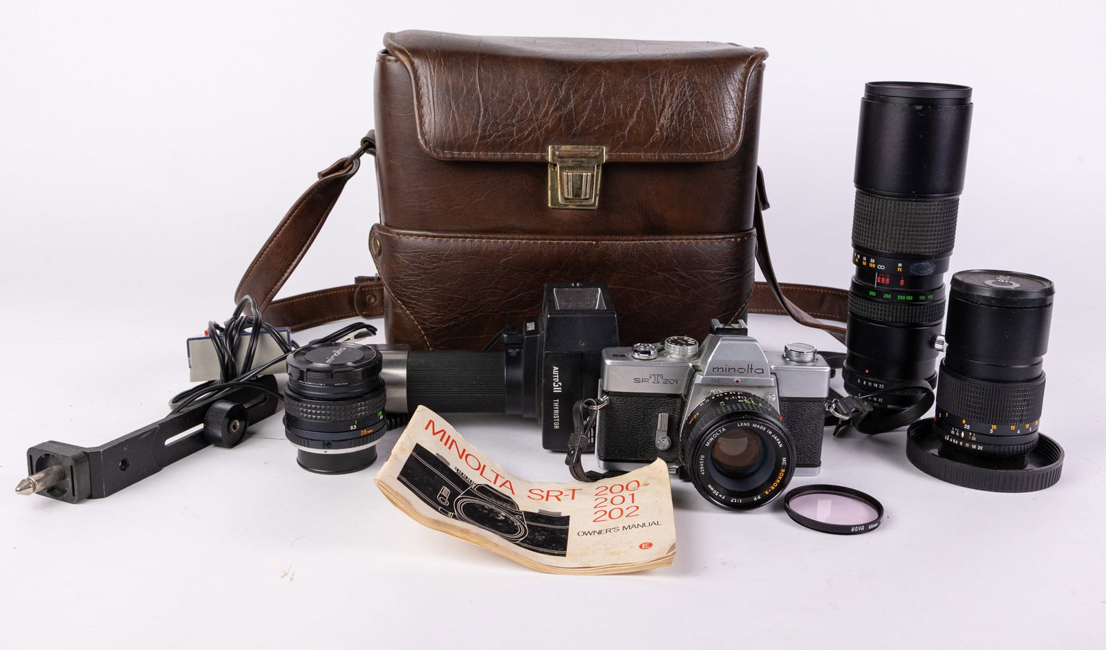 Minolta SRT201 Film Camera with Accessories: Minolta SRT201 Film Camera with Accessories Size 7" x 12" x 12" Literature Brooks Auction – Online Auction Terms & Conditions Contact: (856) 694-2960 | info@brooks.auction READ BEFORE YOU BI