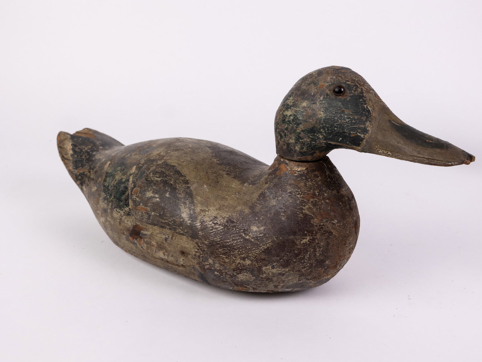 Vintage Mallard Drake Duck Decoy: Hand painted and carved from wood with glass eyes and lead weighted. Significant wear and cracking to paint. The tail is chipped. Unsigned. Size 8" x 6" x 14" Literature Brooks Auction – Online