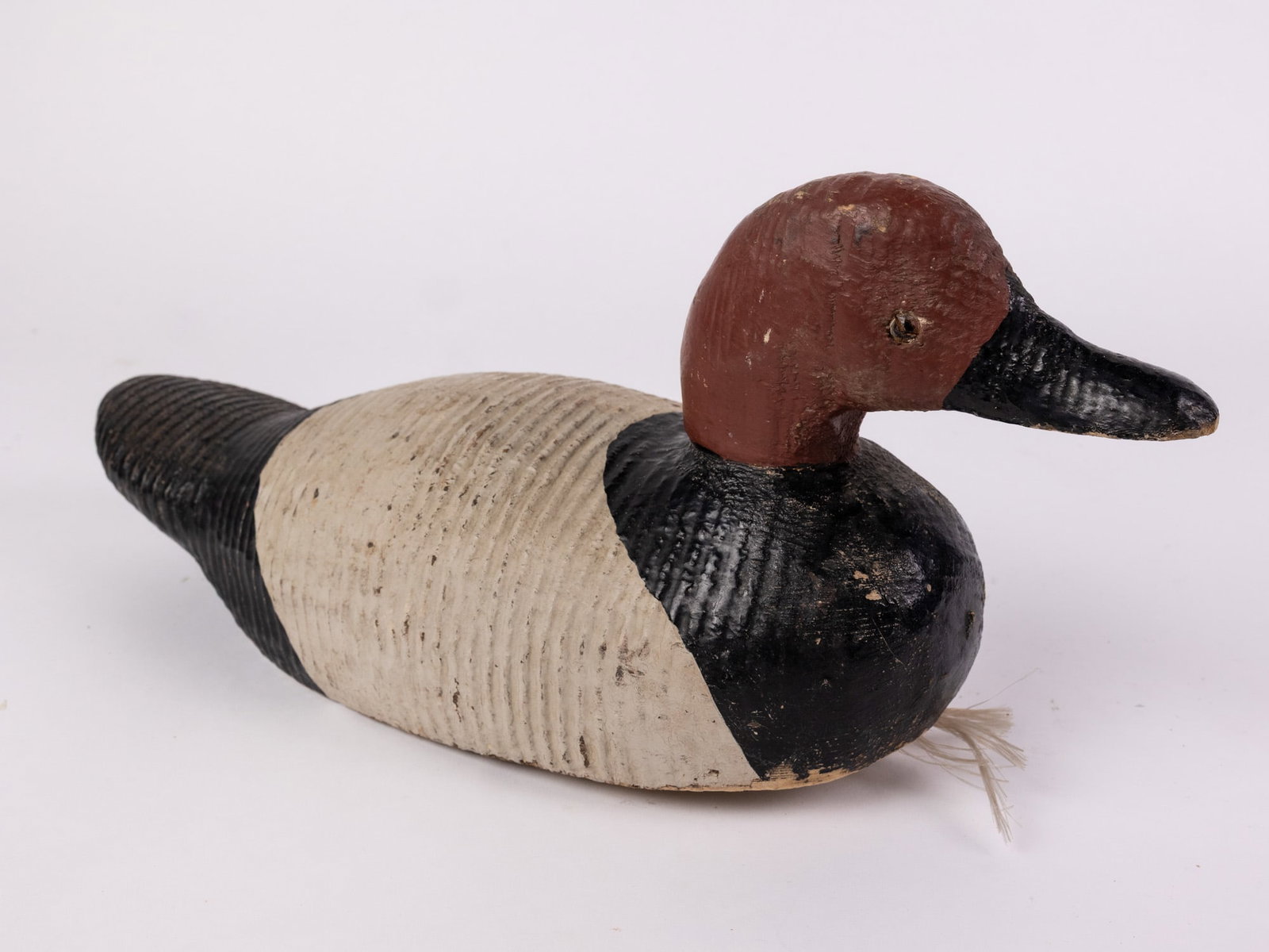 Vintage Canvasback Drake Decoy Signed "Dickerson": Hand painted & carved with a ribbing detail. Lead weighted. One eye is cracked and one eye is missing. Size 7" x 6" x 16" Literature Brooks Auction – Online Auction Terms & Conditions Contact: