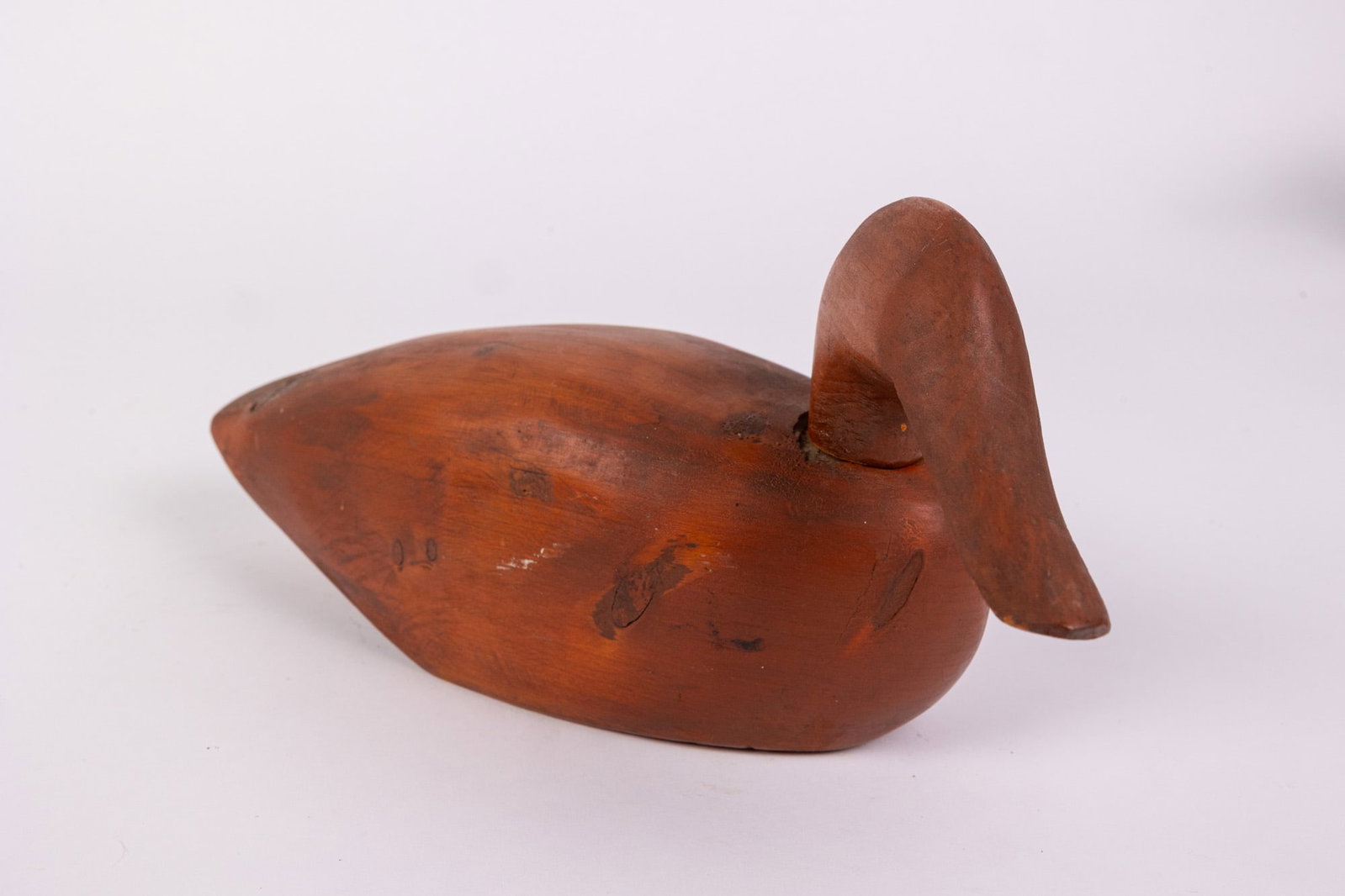 Vintage Hand Carved Duck Decoy w/ Natural Wood Finish: Crafted from solid wood, with a smooth stained finish and prominent wood knots throughout Size 5" x 4" x 12" Literature Brooks Auction – Online Auction Terms & Conditions Contact: (856)