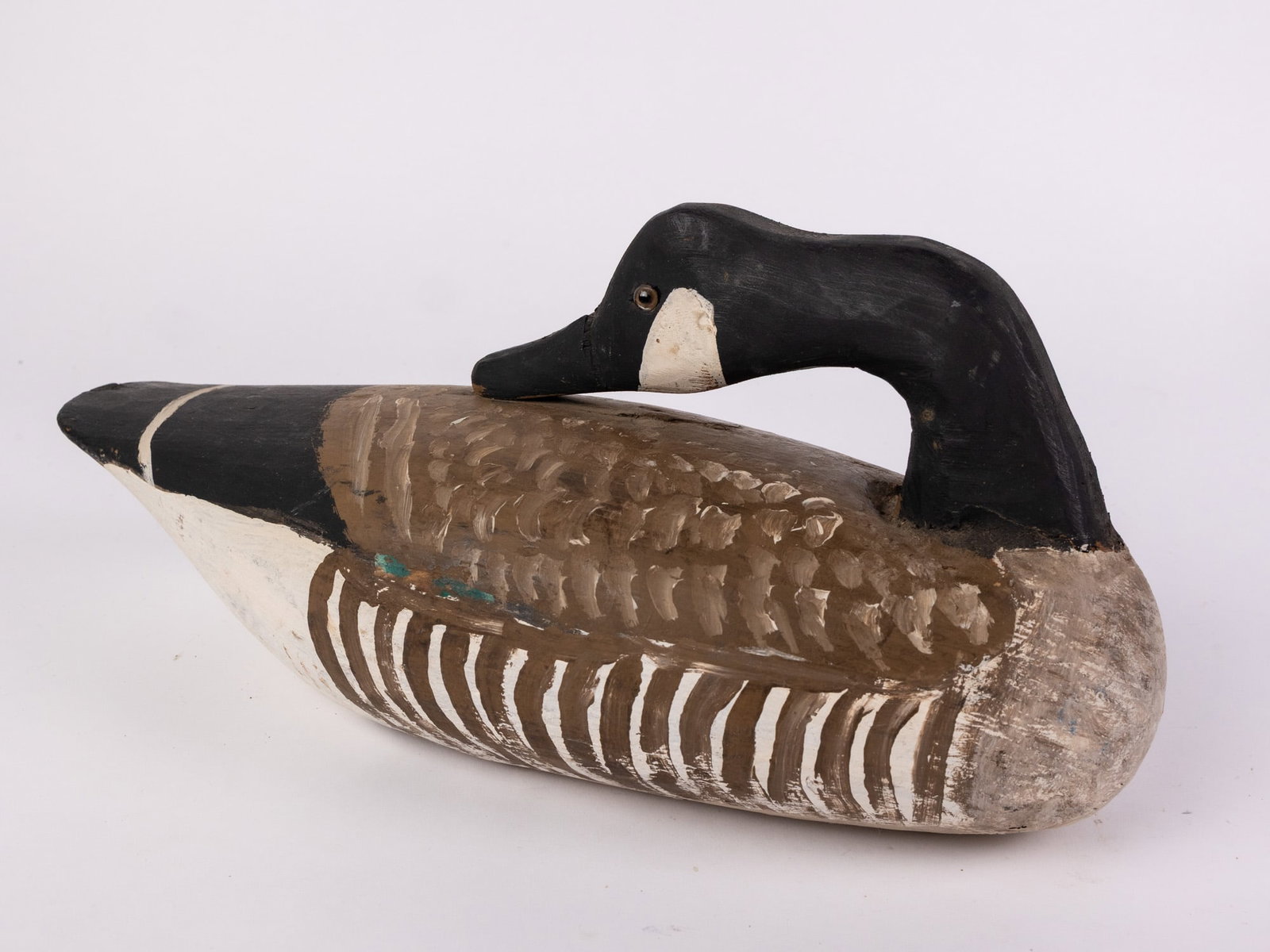 Vintage Carved Wooden Canada Goose Decoy: Hand painted and carved from wood with glass eyes. Unsigned. Minor wear to paint. Size 7" x 7" x 15" Literature Brooks Auction – Online Auction Terms & Conditions Contact: (856) 694-2960 | info