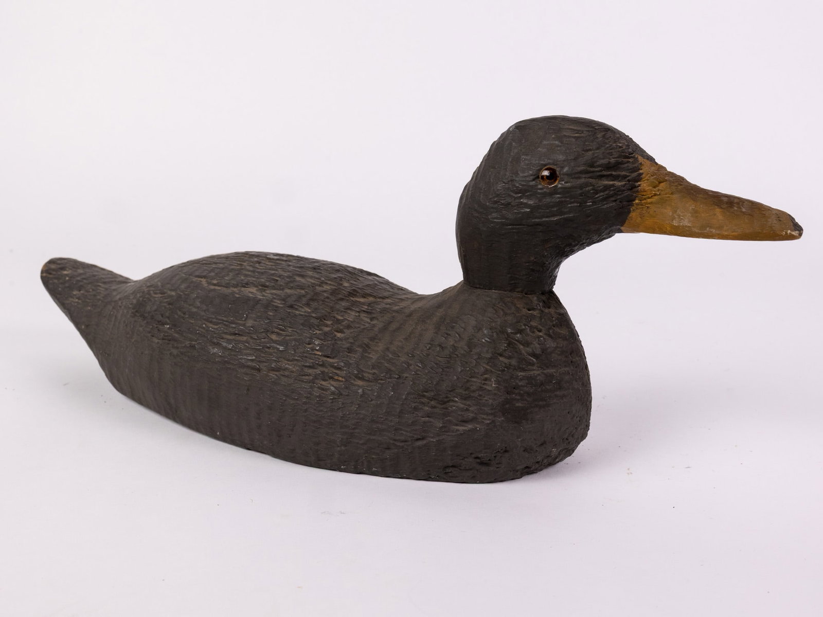 Vintage Wooden Black Duck Decoy: Glass inset eyes & wear to paint consistent w/ age Size 7" x 5" x 16" Literature Brooks Auction – Online Auction Terms & Conditions Contact: (856) 694-2960 | info@brooks.auction READ BEFORE