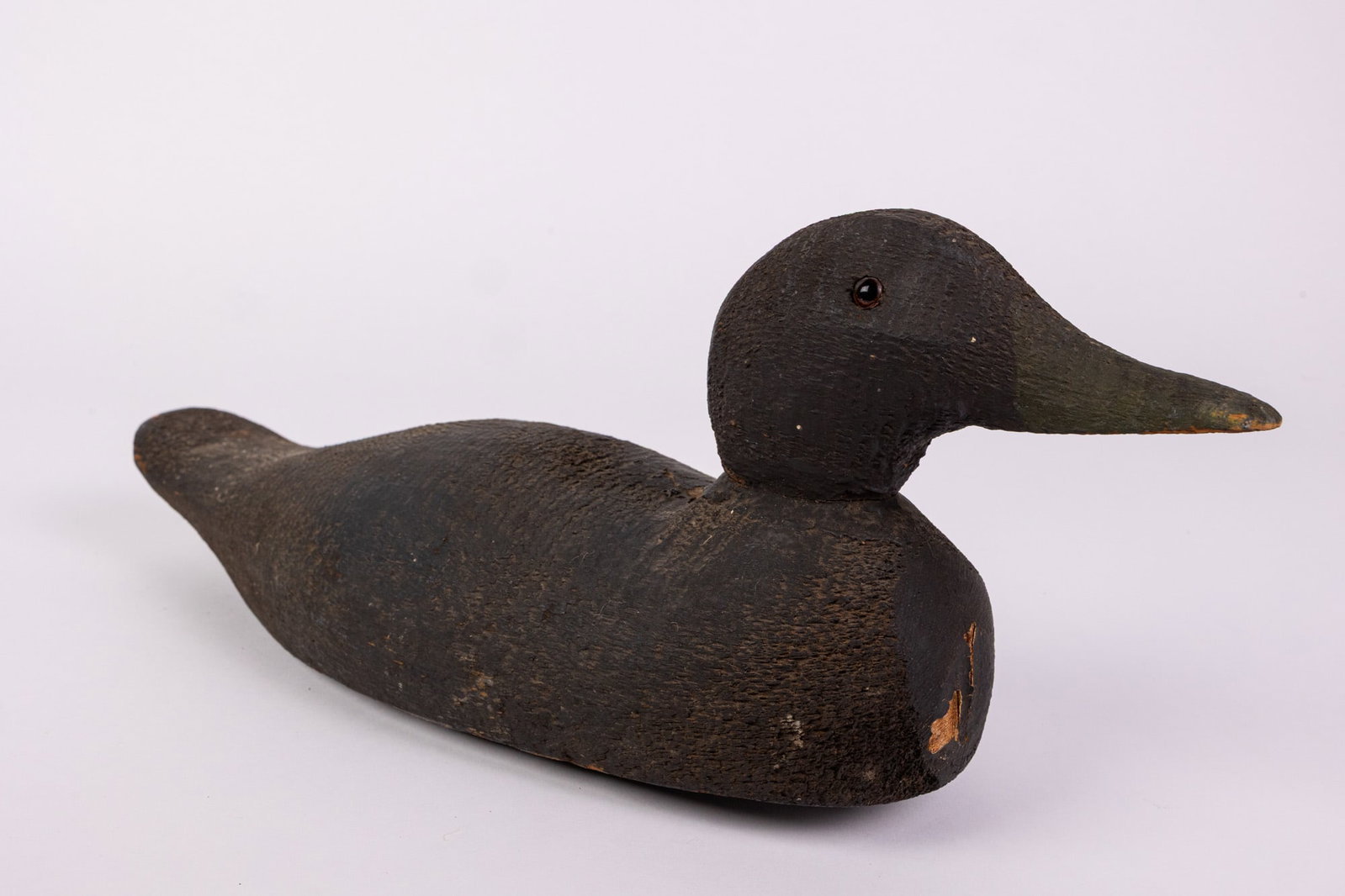 Vintage Wooden Black Duck Decoy: Glass inset eyes & wear to paint consistent w/ age Size 6" x 5" x 13" Literature Brooks Auction – Online Auction Terms & Conditions Contact: (856) 694-2960 | info@brooks.auction READ BEFORE