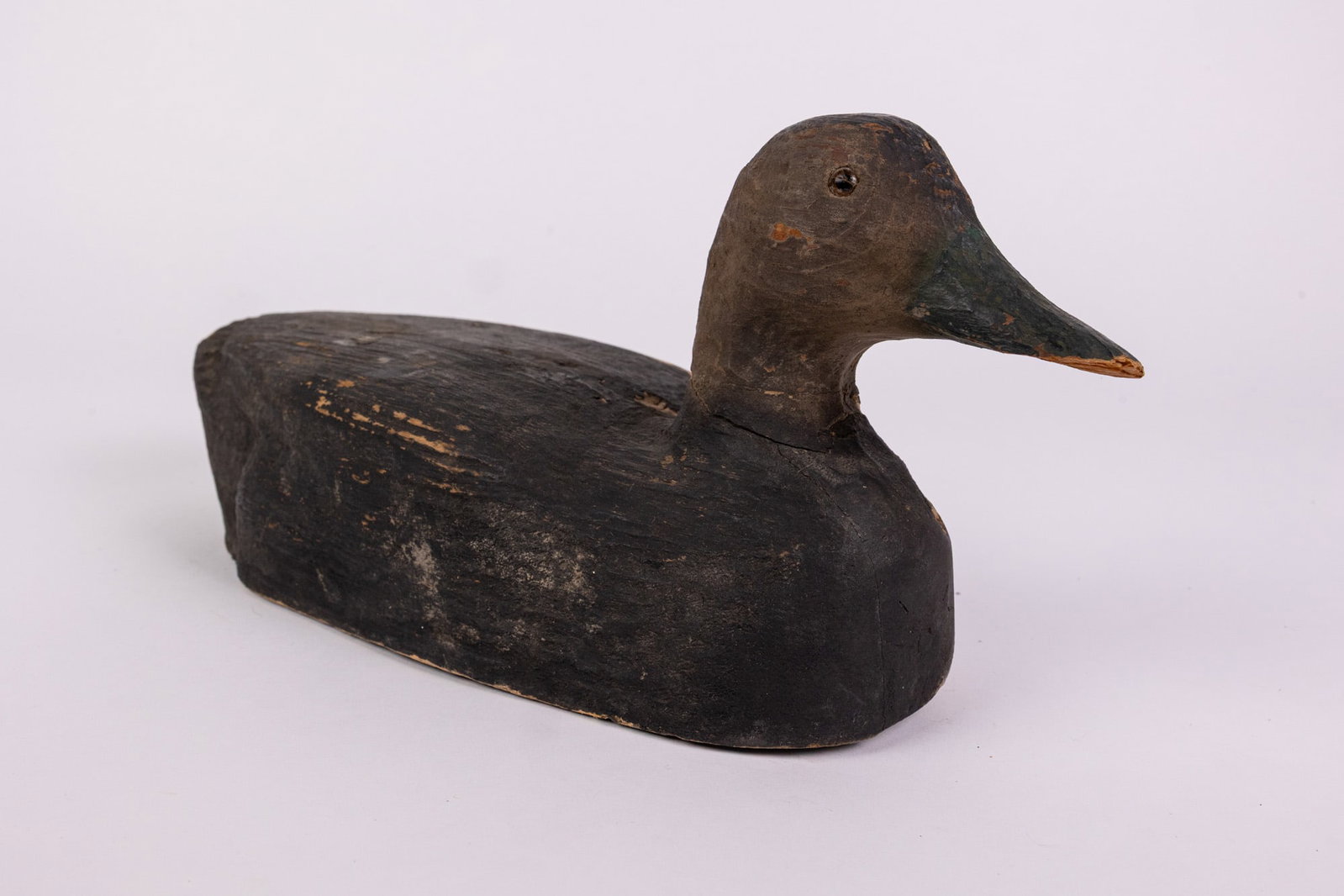Vintage Wooden Black Duck Decoy: Glass inset eyes & wear to paint consistent w/ age Size 6" x 5" x 13" Literature Brooks Auction – Online Auction Terms & Conditions Contact: (856) 694-2960 | info@brooks.auction READ BEFORE