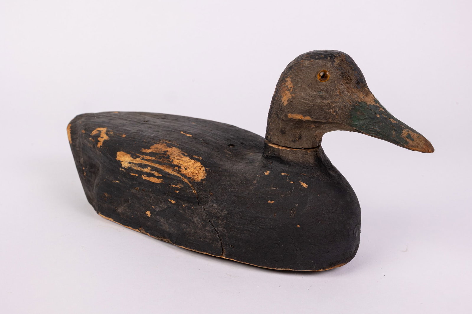 Vintage Wooden Black Duck Decoy: Glass inset eyes, lead weighted & wear to paint consistent w/ age Size 6" x 5" x 13" Literature Brooks Auction – Online Auction Terms & Conditions Contact: (856) 694-2960 | info@brooks.auction