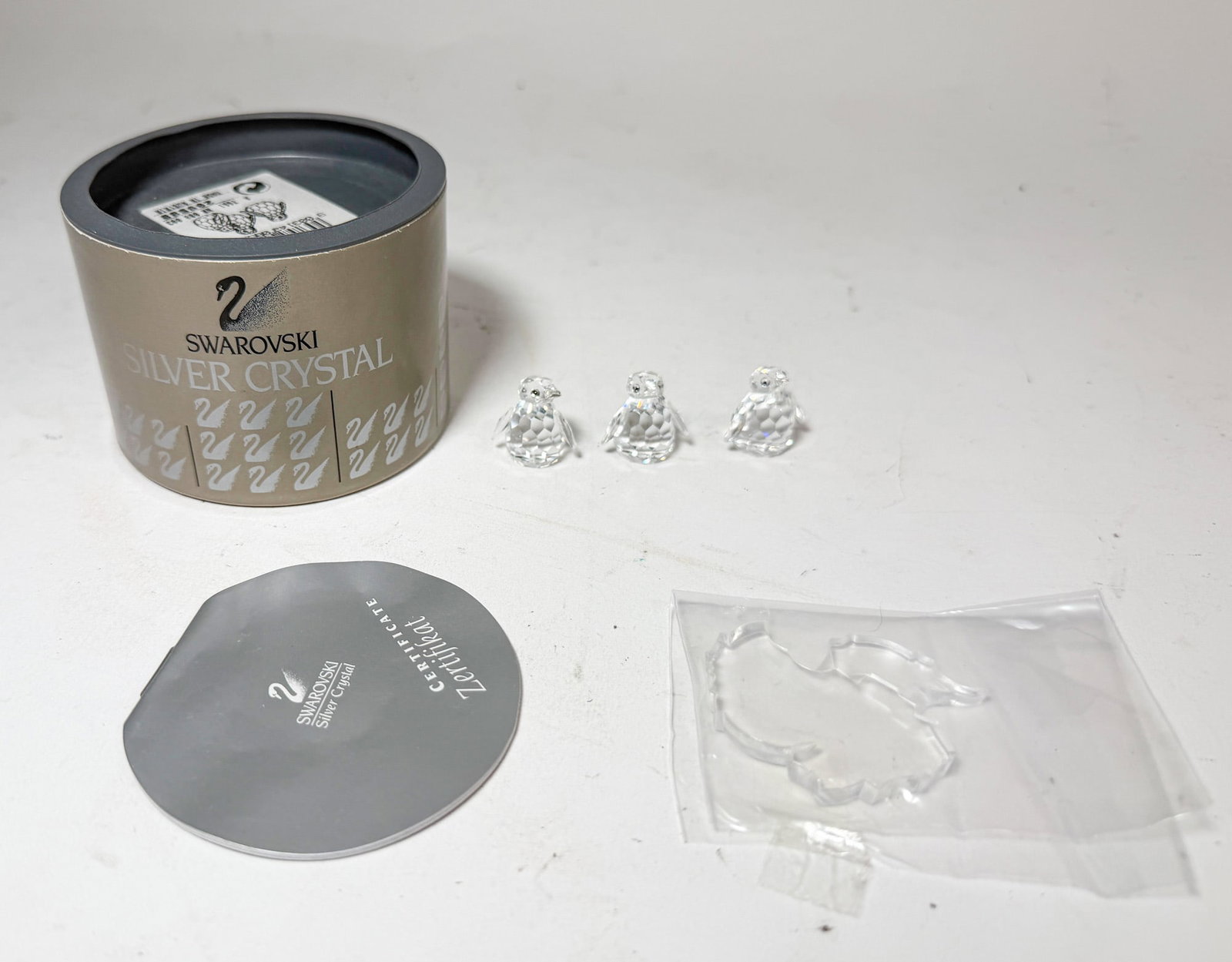 Swarovski Silver Crystal Baby Penguins IOB: Swarovski Silver Crystal Baby Penguins IOB with crystal stand Size 1" H Literature Brooks Auction – Online Auction Terms & Conditions Contact: (856) 694-2960 | info@brooks.auction READ BEFORE