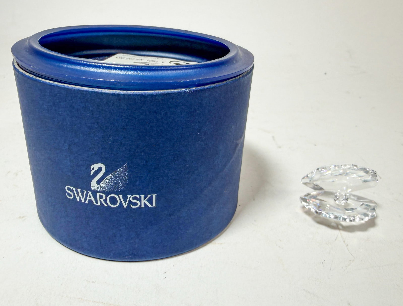 Swarovski " Clam Shell" Crystal Figurine IOB: Swarovski " Clam Shell" Crystal Figurine IOB Size 1"L x .5"H Literature Brooks Auction – Online Auction Terms & Conditions Contact: (856) 694-2960 | info@brooks.auction READ BEFORE YOU BID: We