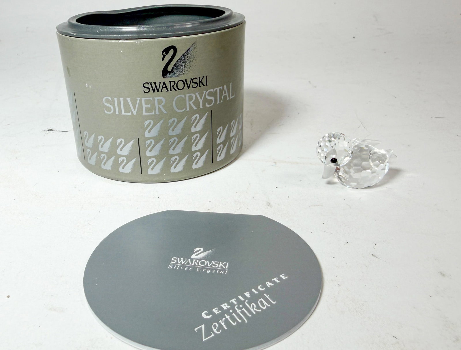 Swarovski Silver Crystal Swimming Duck IOB: Swarovski Silver Crystal Swimming Duck IOB Size 1" H Literature Brooks Auction – Online Auction Terms & Conditions Contact: (856) 694-2960 | info@brooks.auction READ BEFORE YOU BID: We w