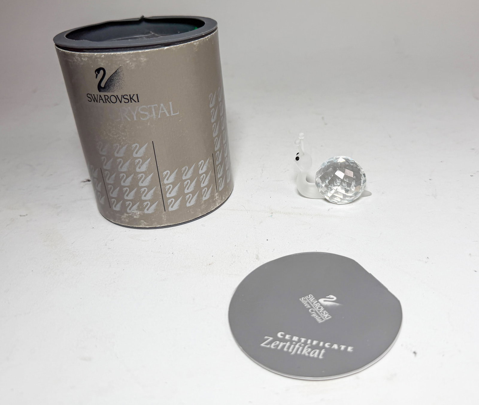 Swarovski Silver Crystal Snail IOB: Swarovski Silver Crystal Snail IOB Size 1.5" H Literature Brooks Auction – Online Auction Terms & Conditions Contact: (856) 694-2960 | info@brooks.auction READ BEFORE YOU BID: We want you to