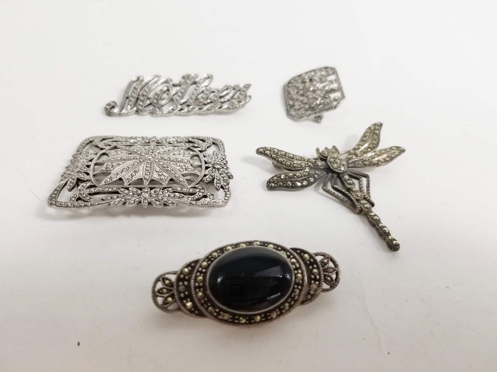 five Art Deco inspired Sterling Silver Brooches: five Art Deco inspired Sterling Silver Brooches earring pairs, bracelet, and rings total weight 42.7 Literature Brooks Auction – Online Auction Terms & Conditions