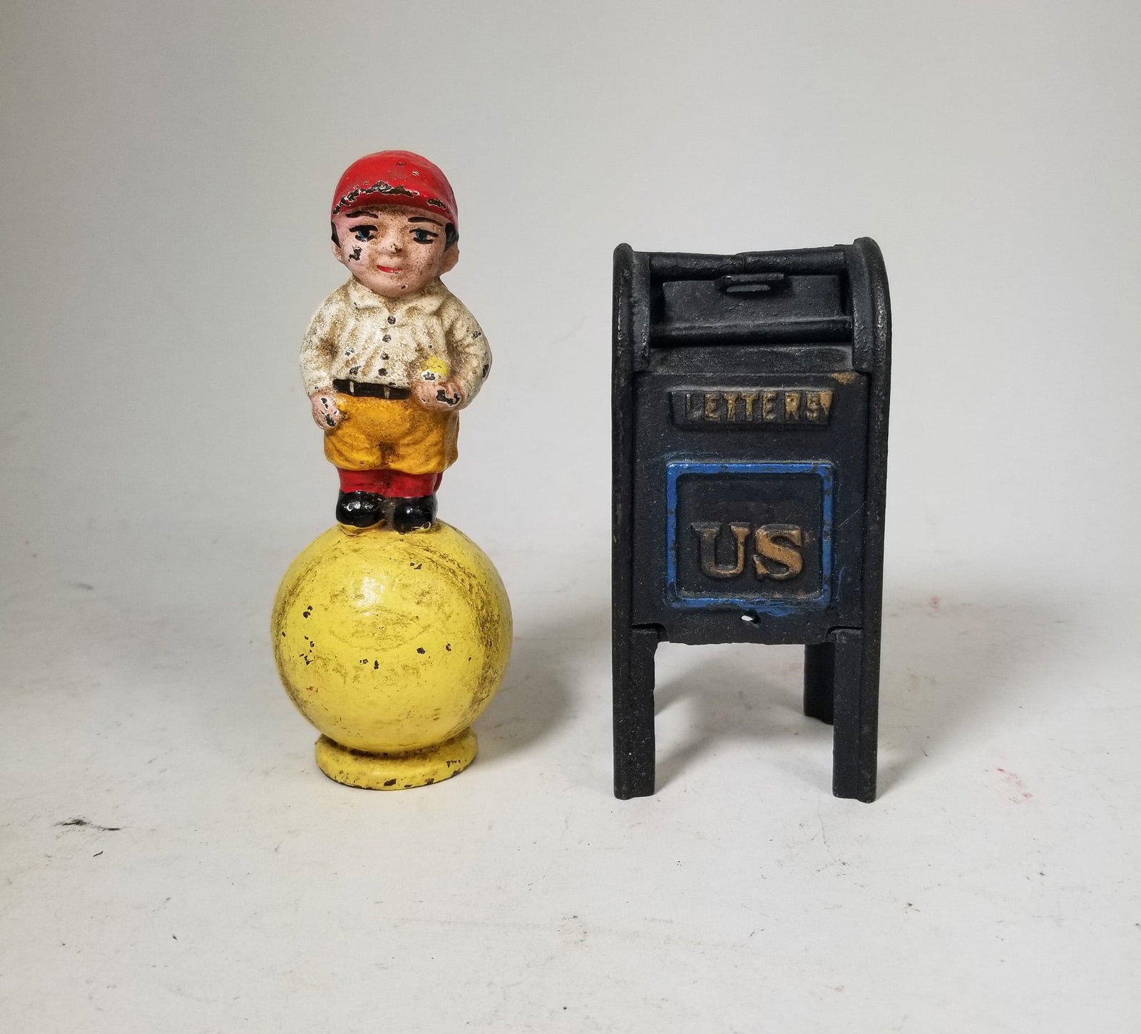 Two Cast Iron Banks: Cast Iron Baseball Boy Still Bank - Cast Iron Air Mail Mailbox Still Bank Size 6" H Literature Brooks Auction – Online Auction Terms & Conditions Contact: (856) 694-2960 | info@brooks.auction <