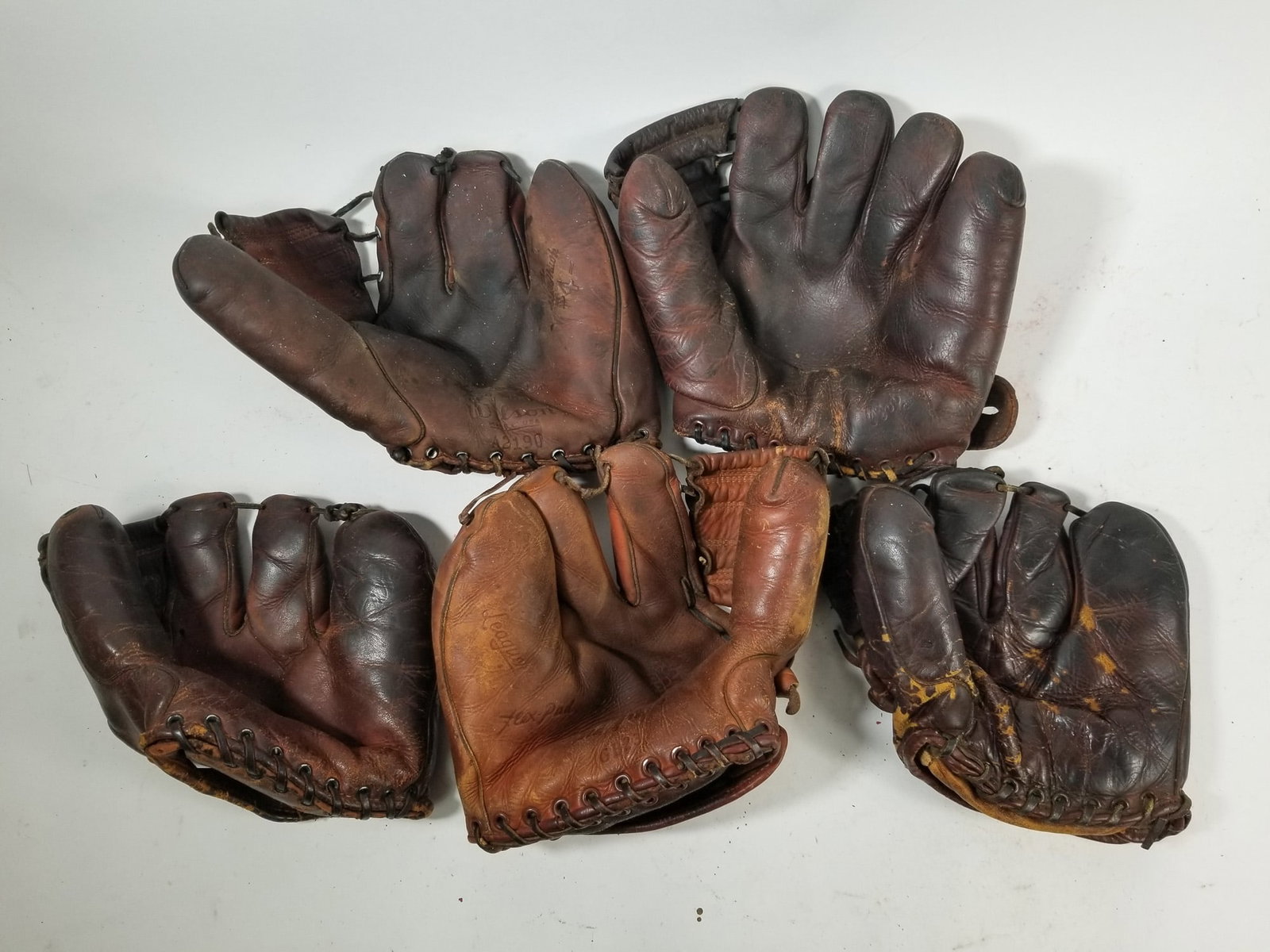 Grouping of Vintage Leather Baseball Gloves: Grouping of Vintage Leather Baseball Gloves featuring Bob Feller model and Wilson brand gloves. Size 7" x 12" x 12" Literature Brooks Auction – Online Auction Terms & Conditions Contact: (856)